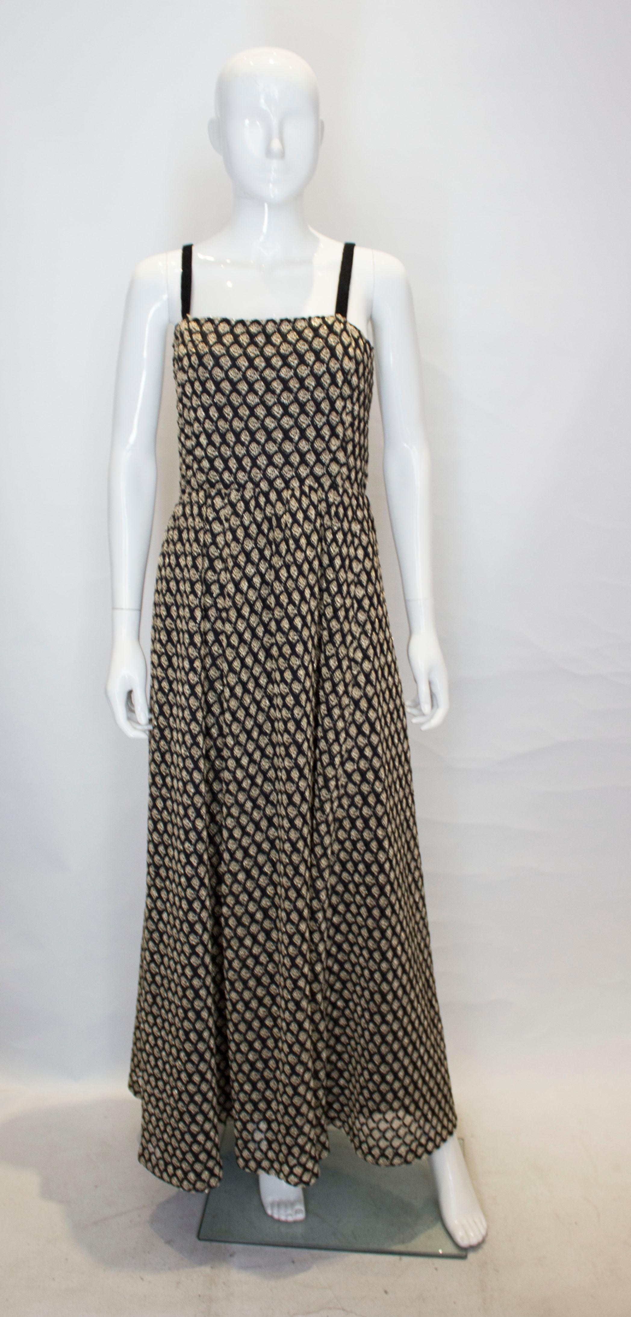  Ein schickes, aufsehenerregendes Kleid in Schwarz und Gold.  Das Kleid ist aus einem schwarz-goldenen Netzstoff mit  ein schwarzes Futter. Es hat Schulterriemen aus schwarzem Samt und ist in der Taille gerafft.