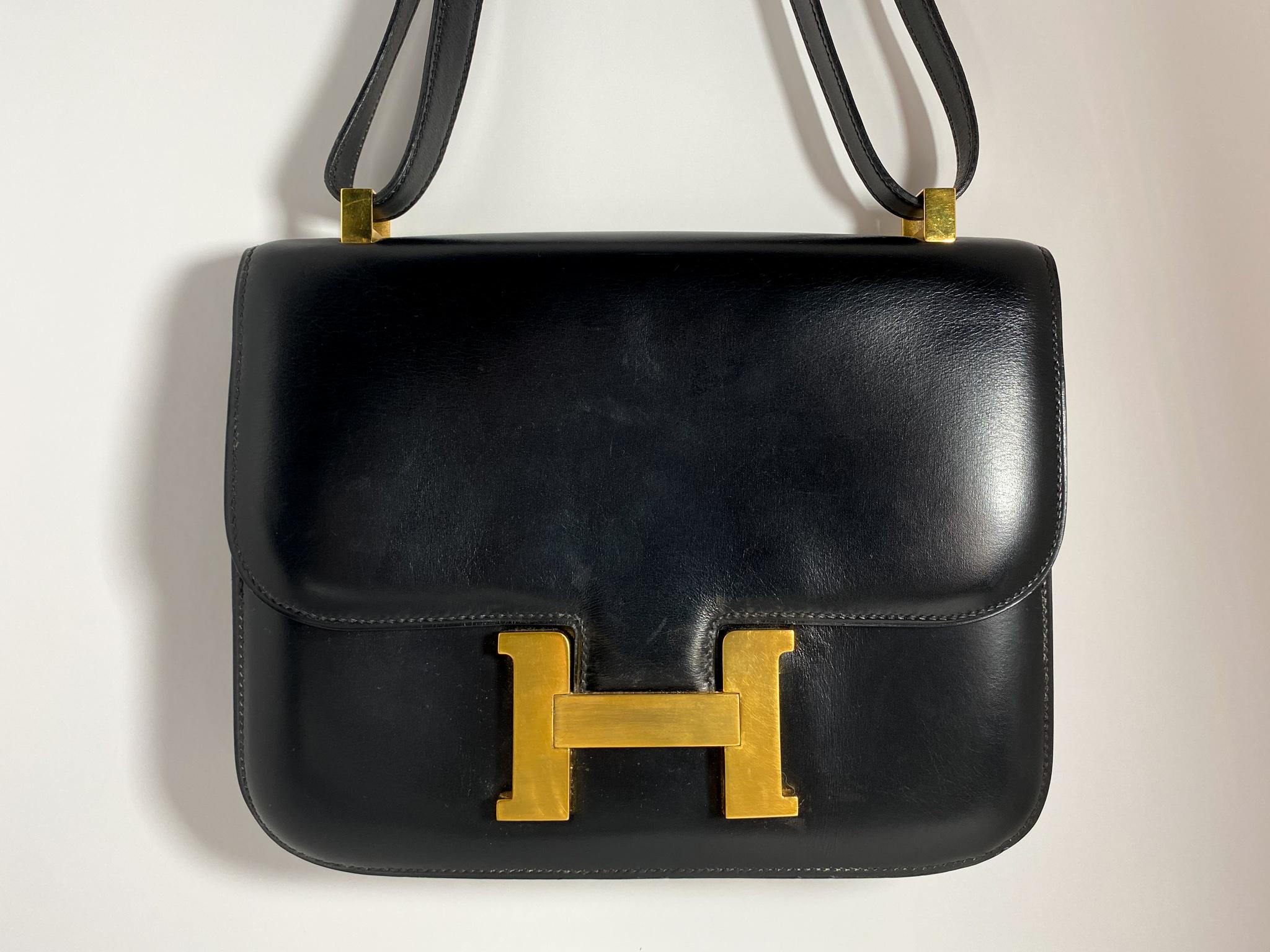 A beautifully structured bag that has aged gracefully, made with black box calf leather, and brushed gold plated hardware. Produced in 1985.

Condition: Good used condition.
Exterior: One exterior pocket, light scuffs and scratches on hardware and