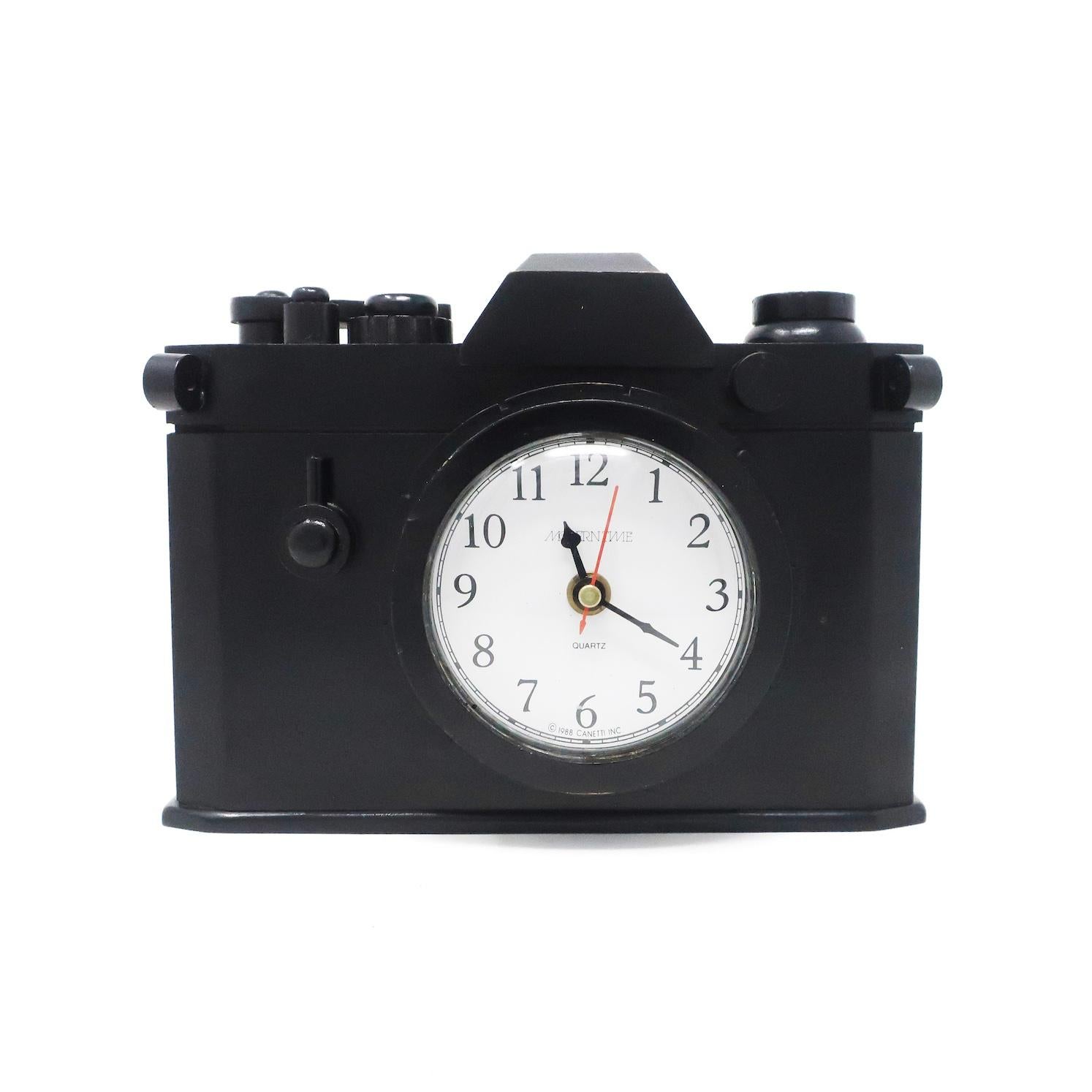 A fantastic post-modern clock by Canetti in the shape of a camera. Clock’s face is set into the cameras lens and body is solid wood with a moving film advance lever. In good vintage condition with wear consistent with age and use, including evidence