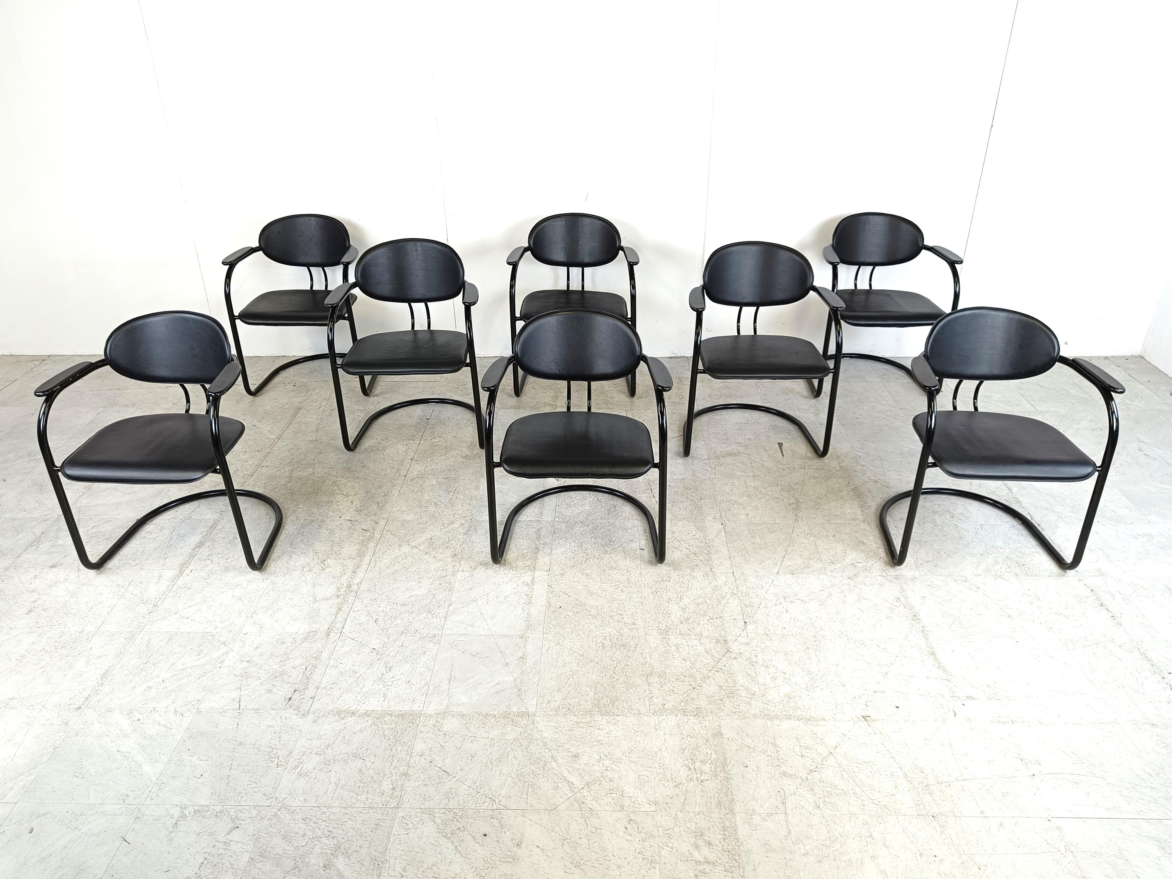 Chaises de salle à manger vintage à piétement luge fabriquées en Italie. Ils sont dotés d'un cadre en métal noir finement conçu, d'une assise et d'un dossier en cuir noir et d'accoudoirs en bois laqué.

Design/One élégant et intemporel.

Années 1980