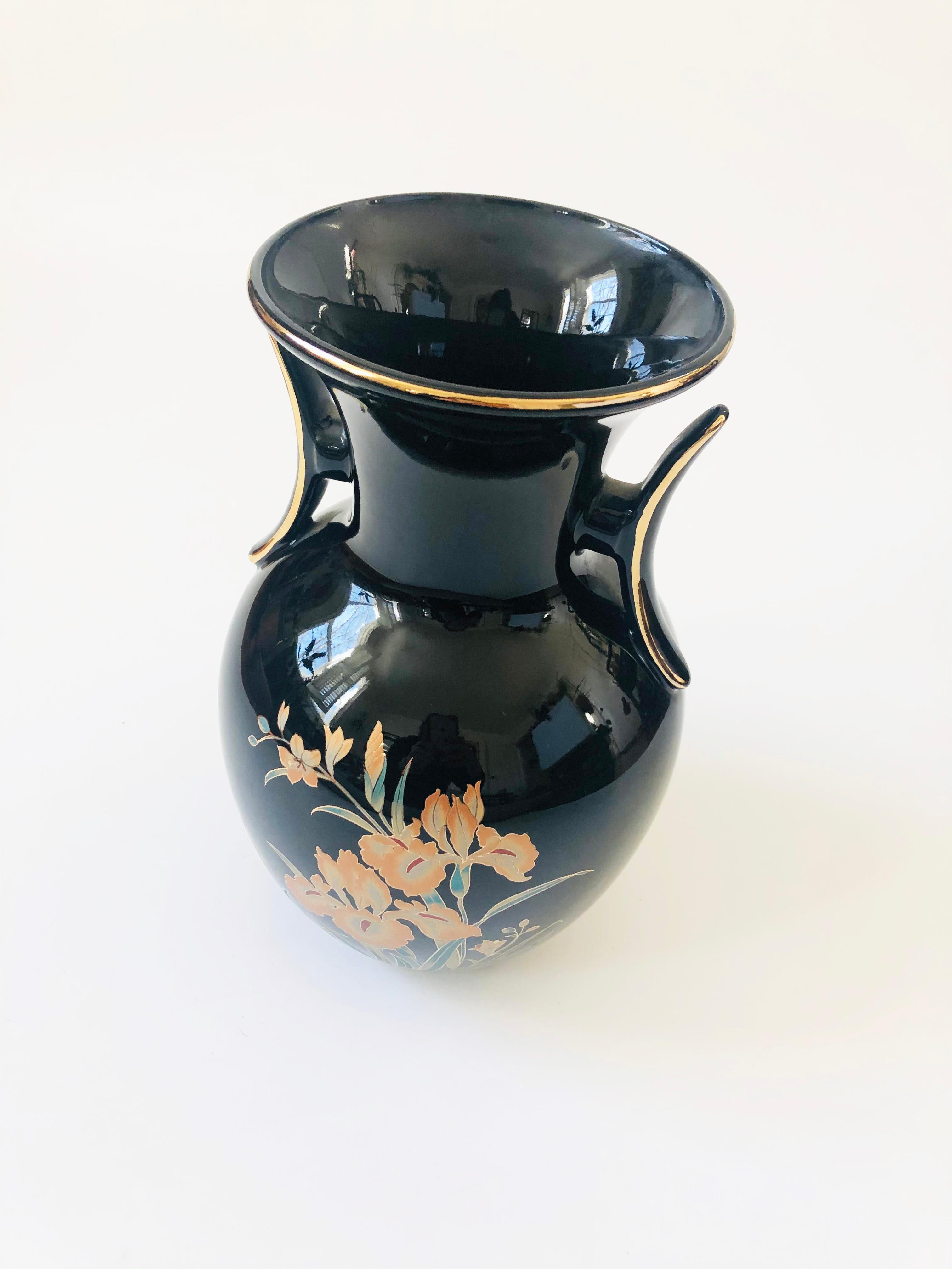 A lovely vintage ceramic vase. Glossy black finish with a highly detailed iris design in gold, pale orange and green applied to the surface. Made in Japan.