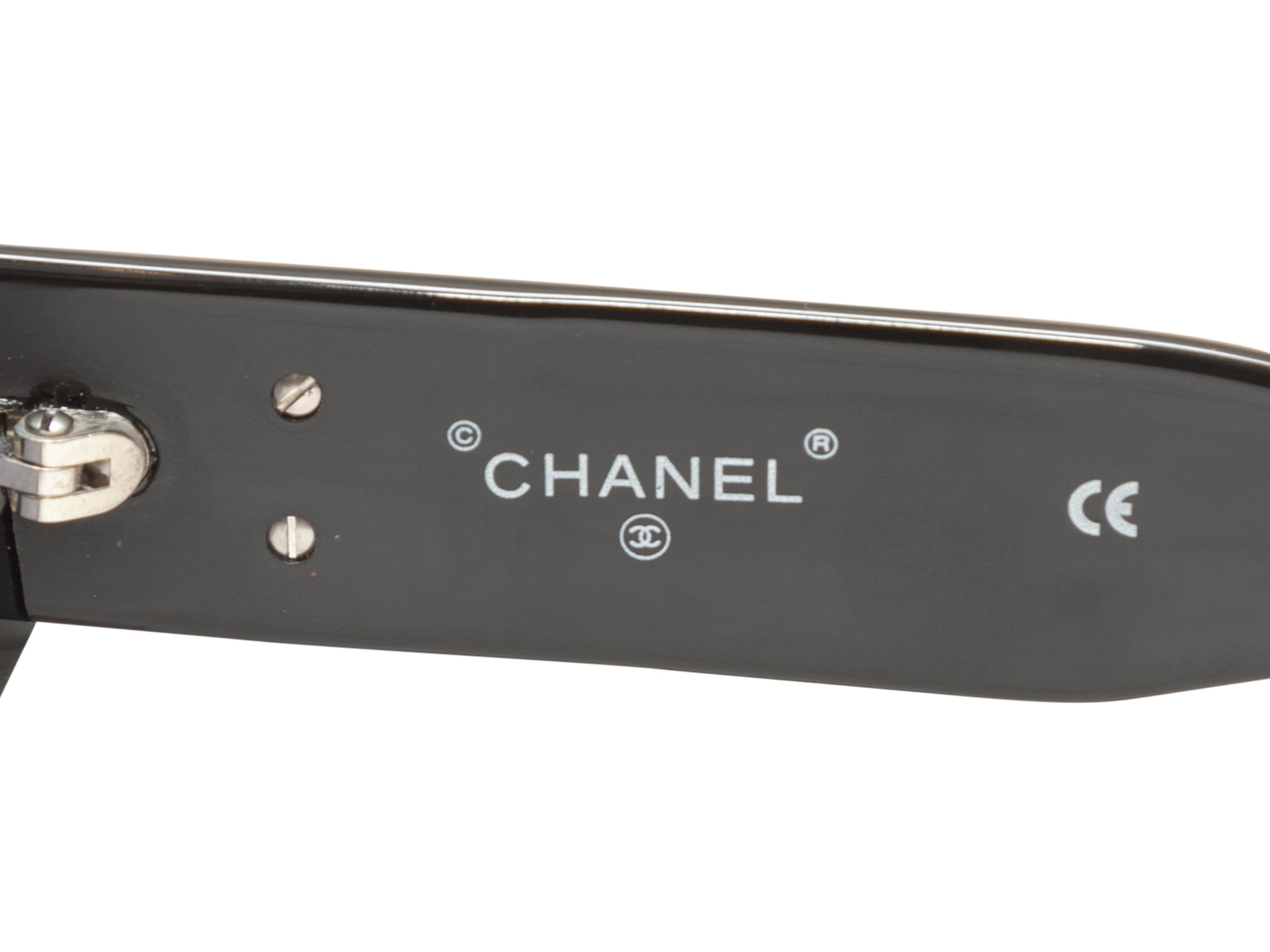 Vintage black acetate narrow sunglasses by Chanel. Circa 1990s. Grey tinted lenses. CC adornments at temples. 1.5