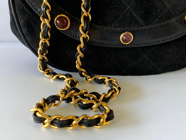 One of the most scarce Coco Chanel handbags - black quilted suede and kidskin lamb leather in a half-moon shape, with a gilt-metal woven leather chain. The chic bag is adorned by large 