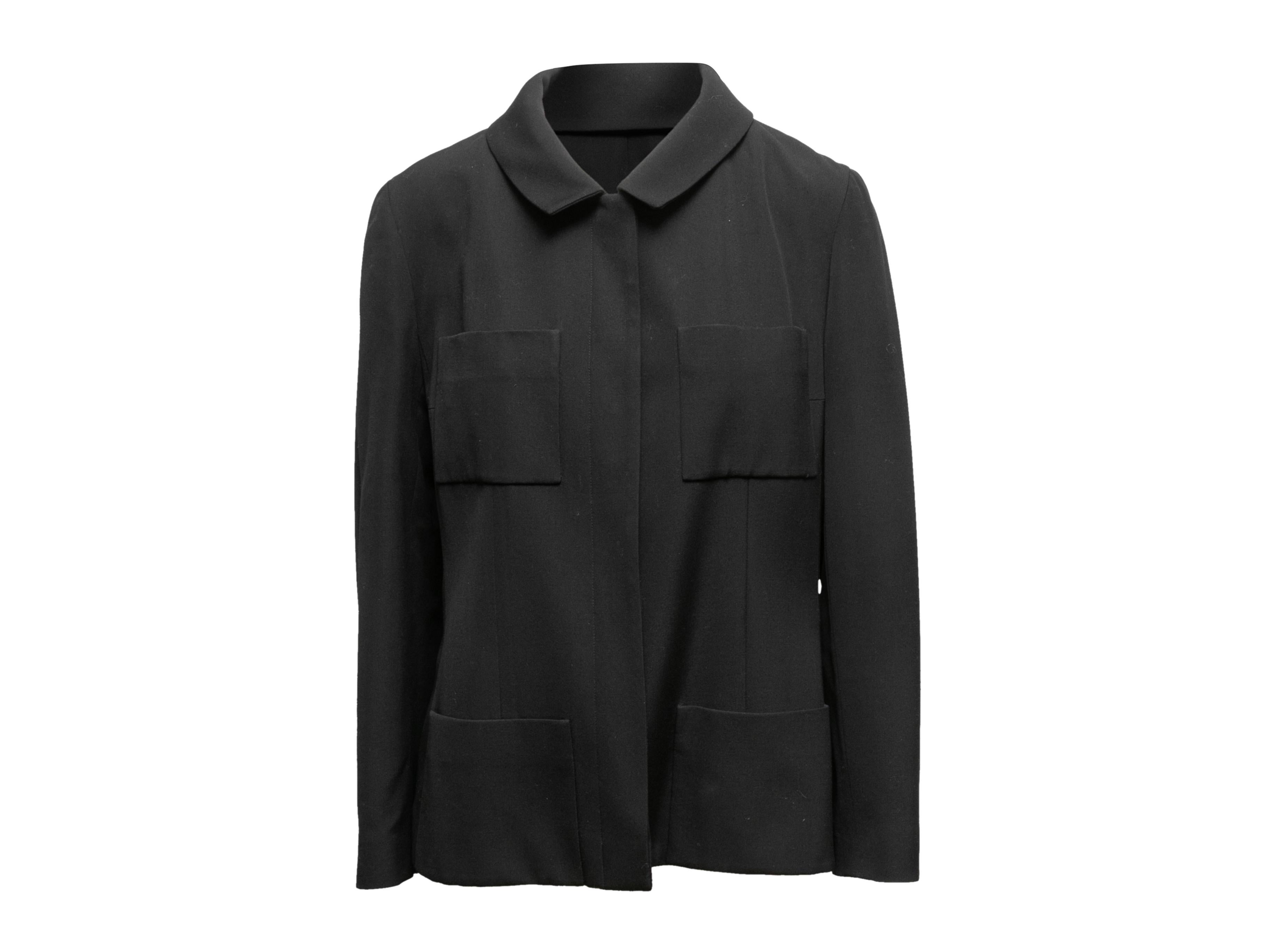 Vintage black wool jacket by Chanel. From the Spring/Summer 2001 Collection. Pointed collar. Four pockets. Concealed front closure. 36