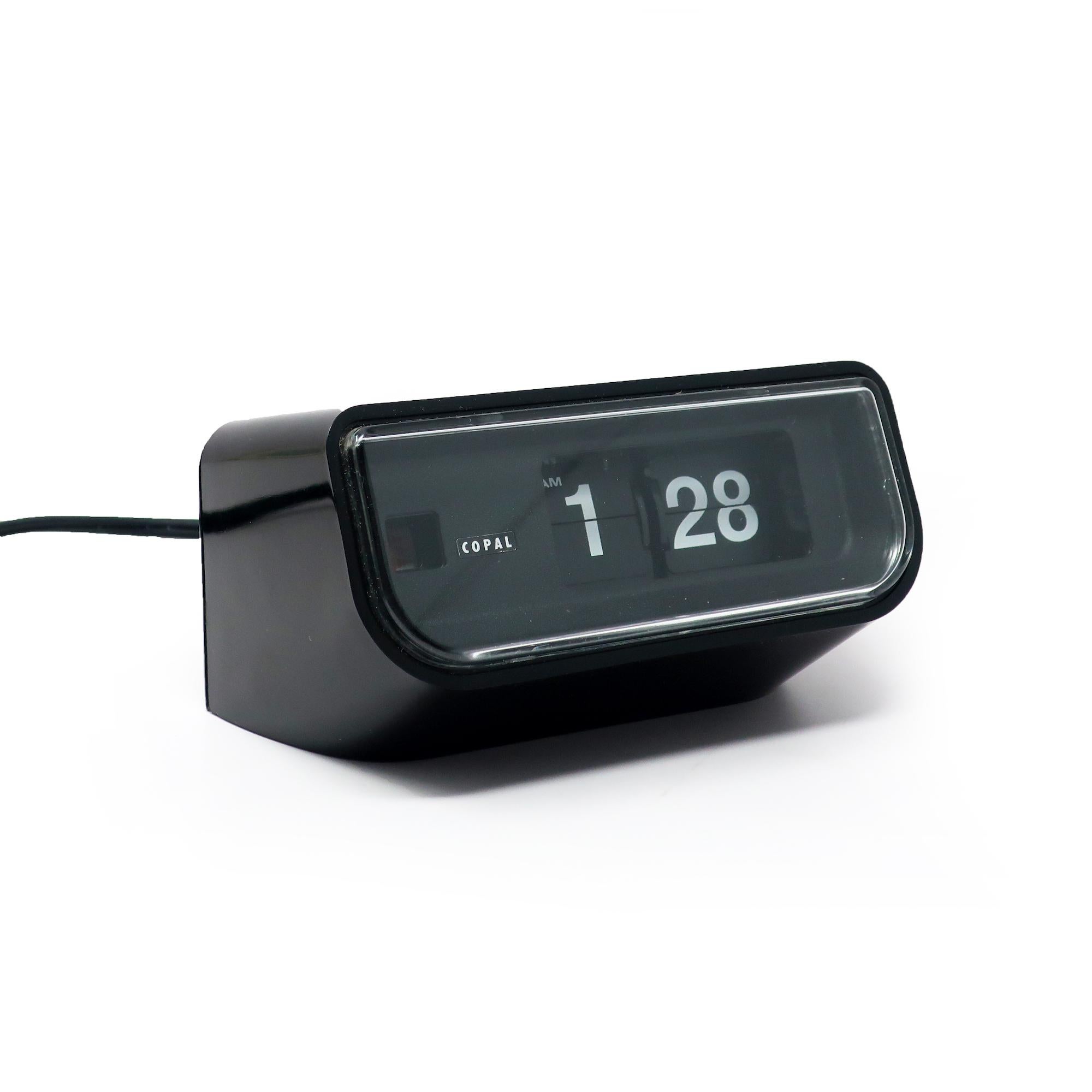 Precioso reloj abatible Copal Modelo 225, moderno de mediados de siglo, con caja de plástico negro, esfera negra, números blancos y frontal de plástico transparente.  Los minutos y las horas giran a medida que pasa el tiempo, proporcionando un