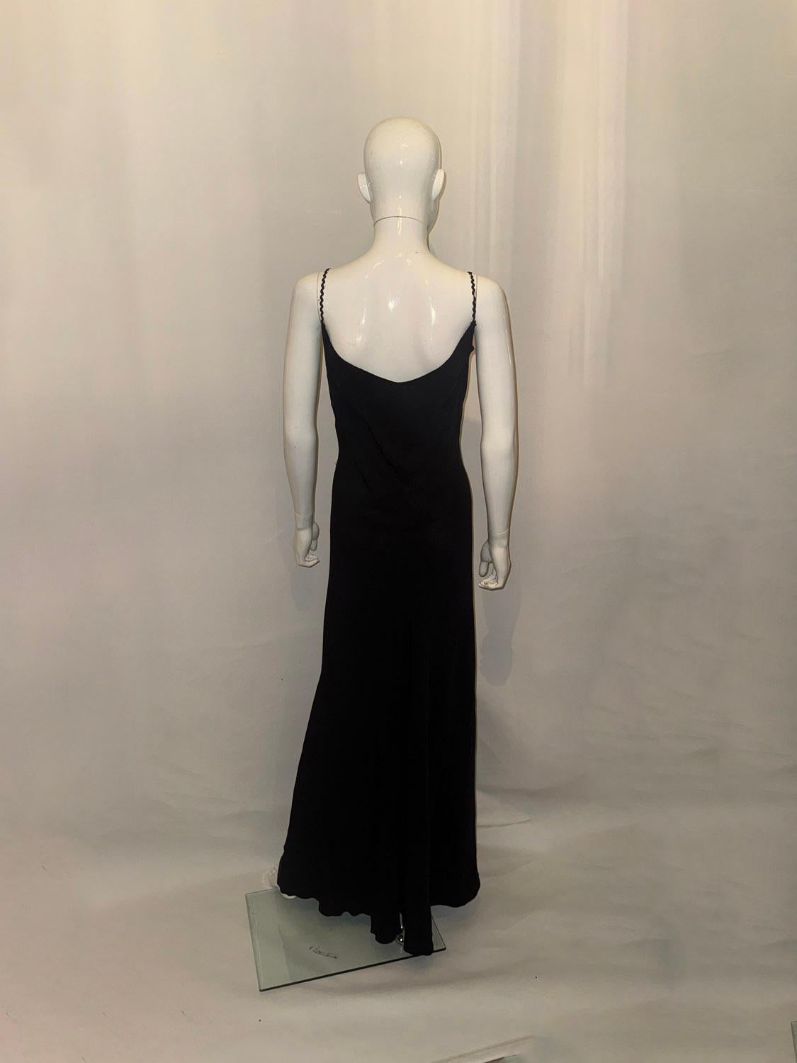 Ein atemberaubendes und sexy Vintage-Krepp-Slipkleid. Das schwarze Kleid hat hübsche Schulterträger und einen tiefen V-Ausschnitt und Rückenausschnitt. 
Maße: Oberweite bis zu 38'', Länge 63''