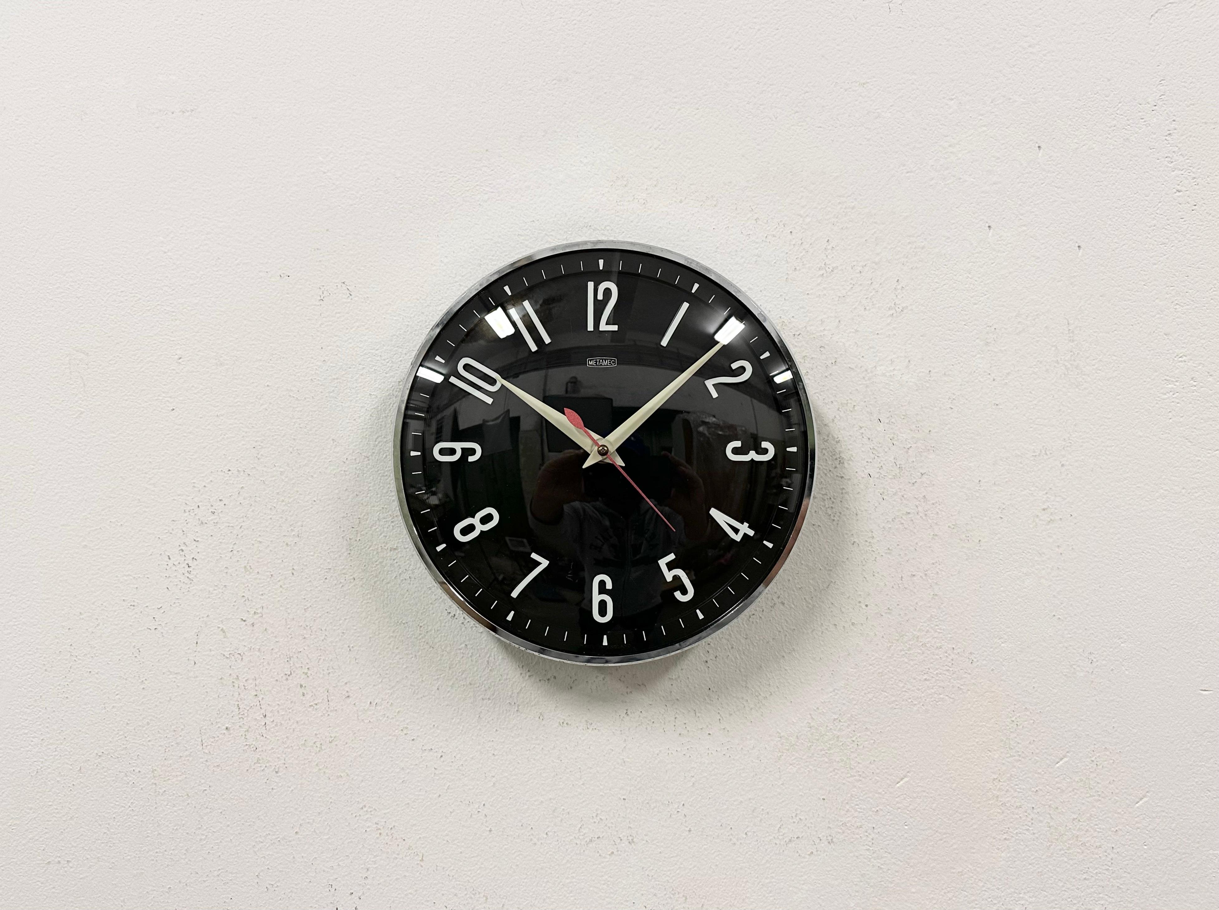 Metamec wall clock was made in United Kingdom during the 1970s. It features a black bakelite body with chrome ring, an aluminium hands and a curved clear glass cover. Original electric movement ( 220 V ) works perfectly . The diameter of the clock