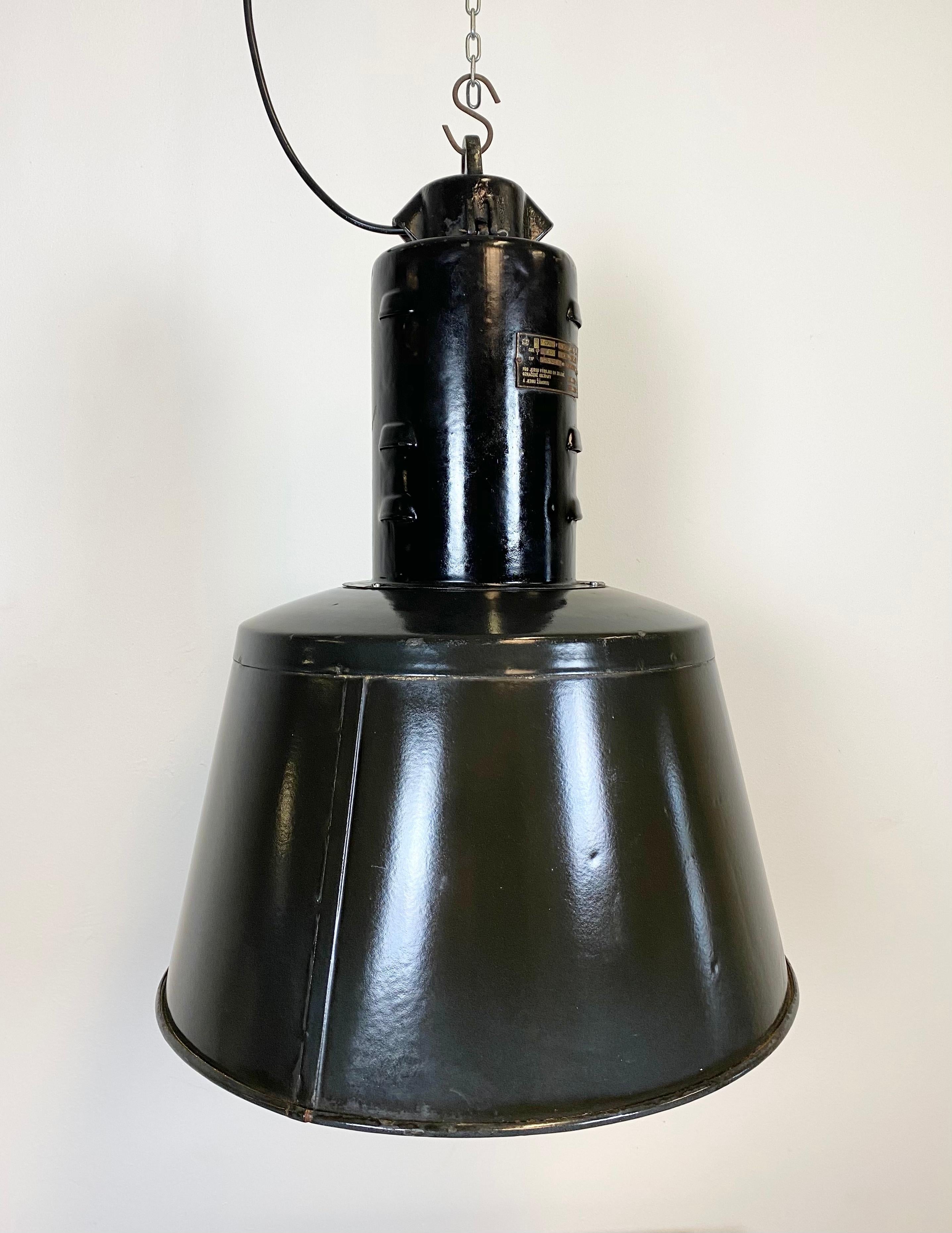 Rare black enamel industrial pendant lamp made during the 1950s in former Czechoslovakia. White enamel interior. Cast iron top. Two new porcelain sockets for E 27 lightbulbs. New wire. The weight of the lamp is 5kg.