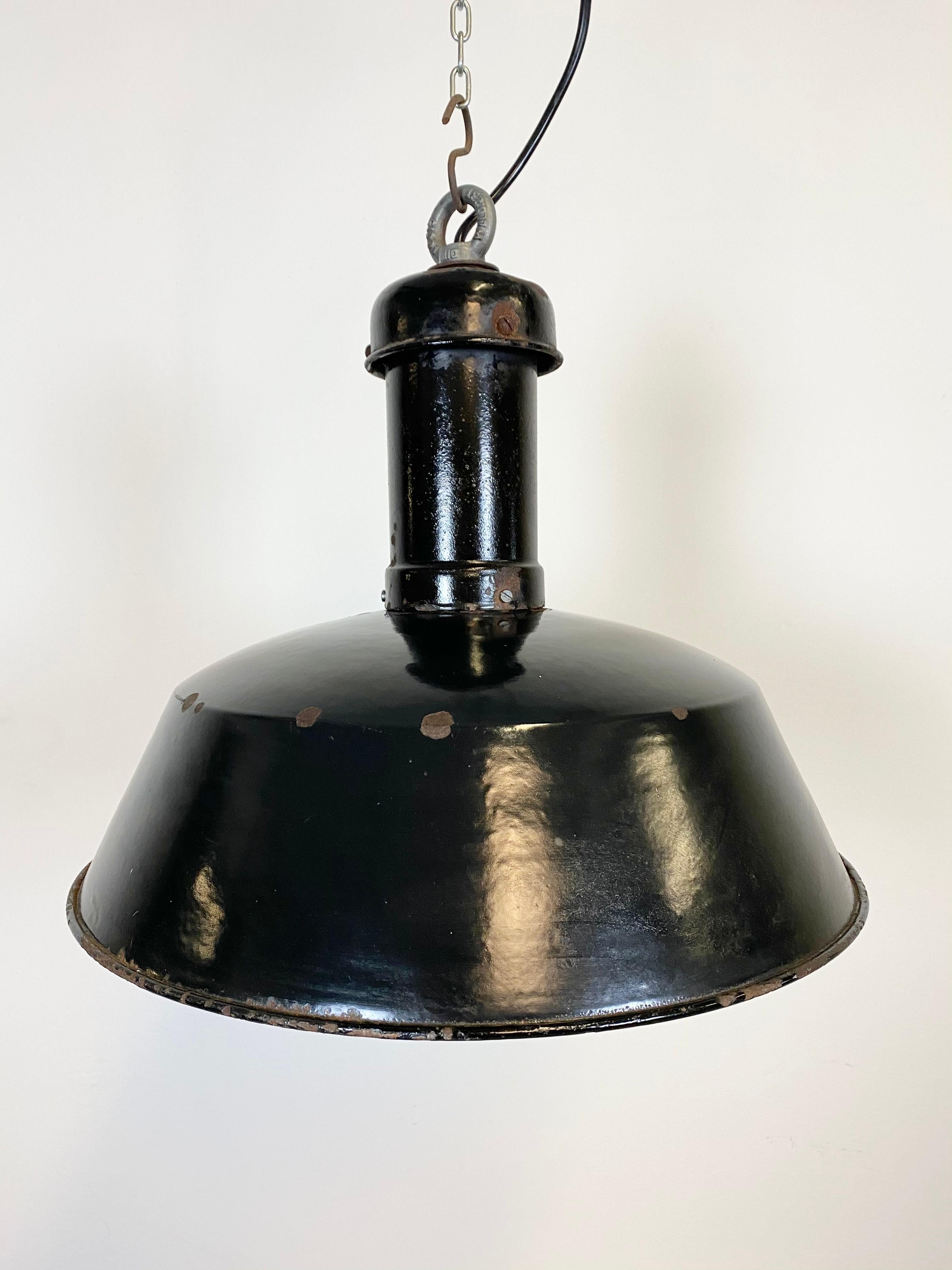 Pendant lamp from former Czechoslovakia, previously used in a factories. Made from enamelled metal. Black outside, white interior. Iron top. New porcelain socket for E 27 lightbulbs and wire. Measure: Diameter 41 cm. Weight: 3 kg.