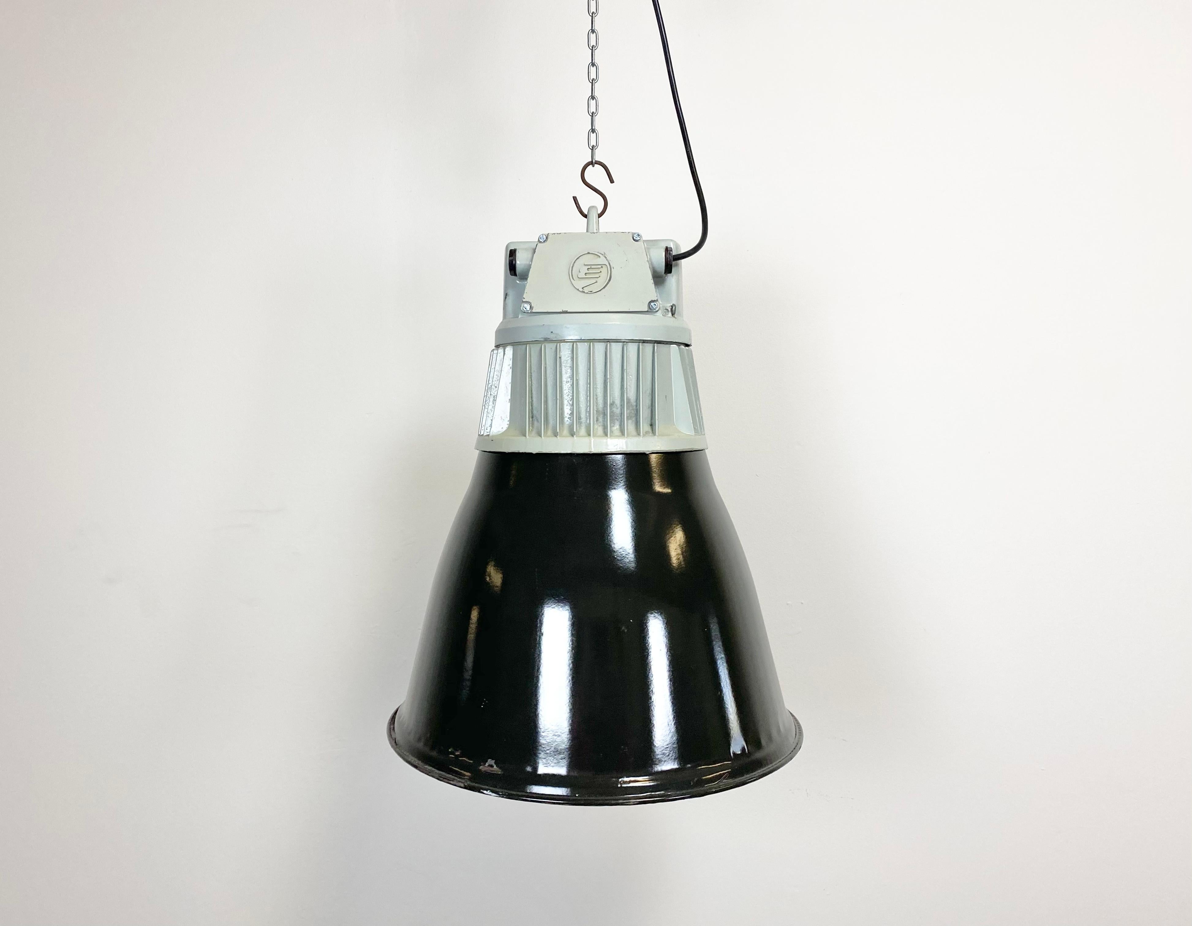 - Industrial hall lamp
- Manufactured by Elektrosvit
- Produced in former Czechoslovakia during the 1960s
- Black enamel shade with white interior
- Grey cast aluminium top
- Weight: 6 kg
- New porcelain socket for E 27 lightbulbs and wire
-