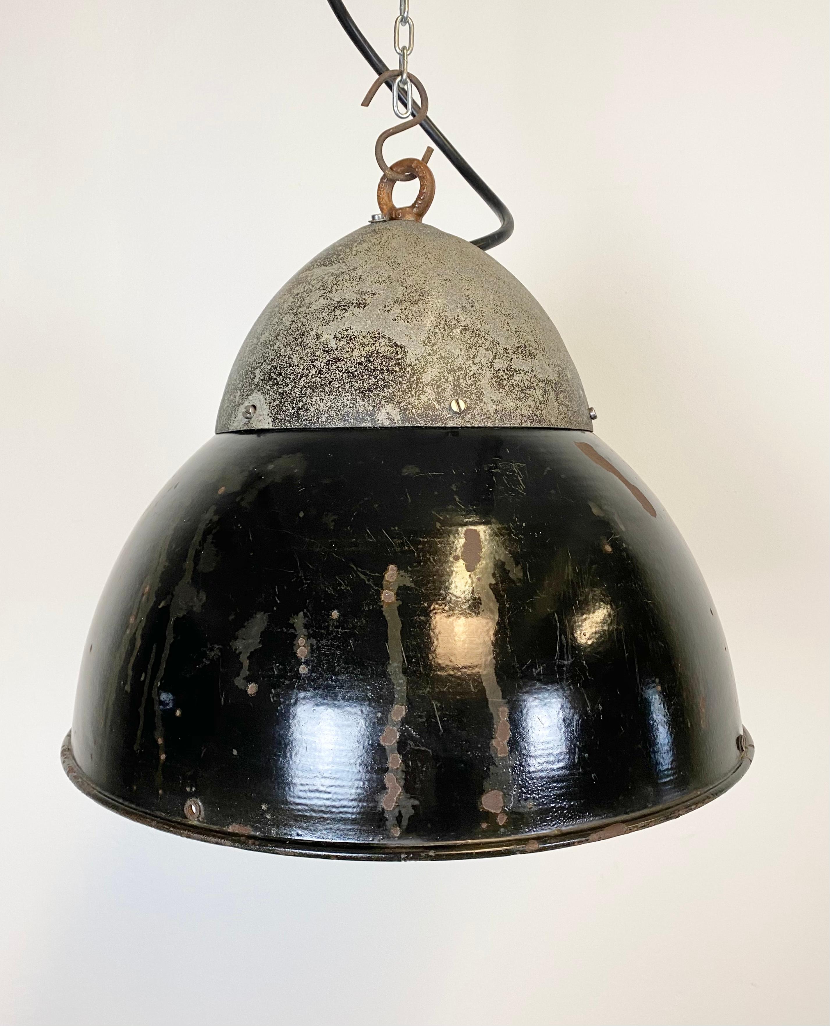 Lampada a sospensione industriale vintage proveniente dall'ex Cecoslovacchia, realizzata negli anni Trenta. La lampada ha una cupola in ferro grigio e un paralume in smalto nero. Interni bianchi. Nuova presa in porcellana per lampadine E27. Un nuovo
