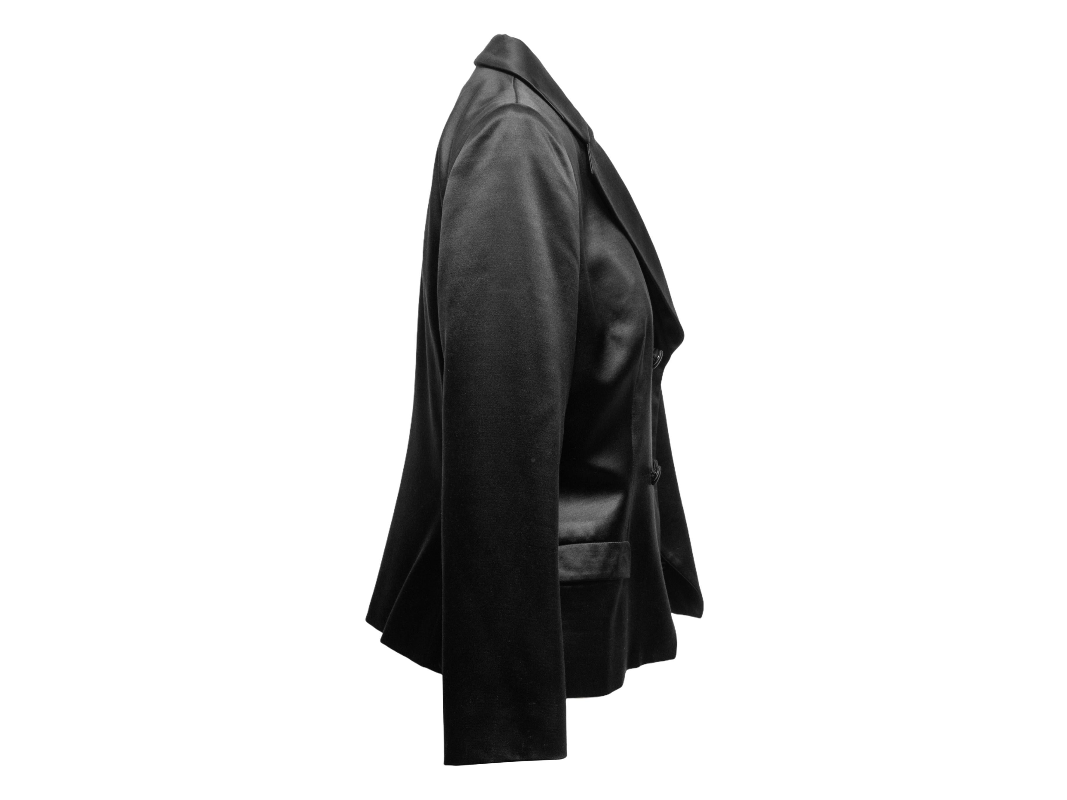 Vintage black wool and silk-blend double-breasted jacket by Giorgio Armani. Notched lapel. Dual welt pockets at hips. Front button closures. 35