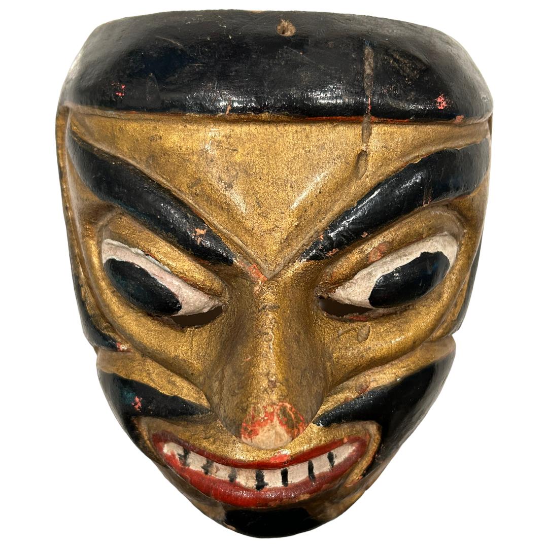 Ce masque de danse noir/doré vintage de Bali Topeng est une véritable œuvre d'art, sculptée à la main dans du bois par des artistes balinais.  La danse Topeng est une forme dramatique de danse indonésienne dans laquelle un ou plusieurs artistes