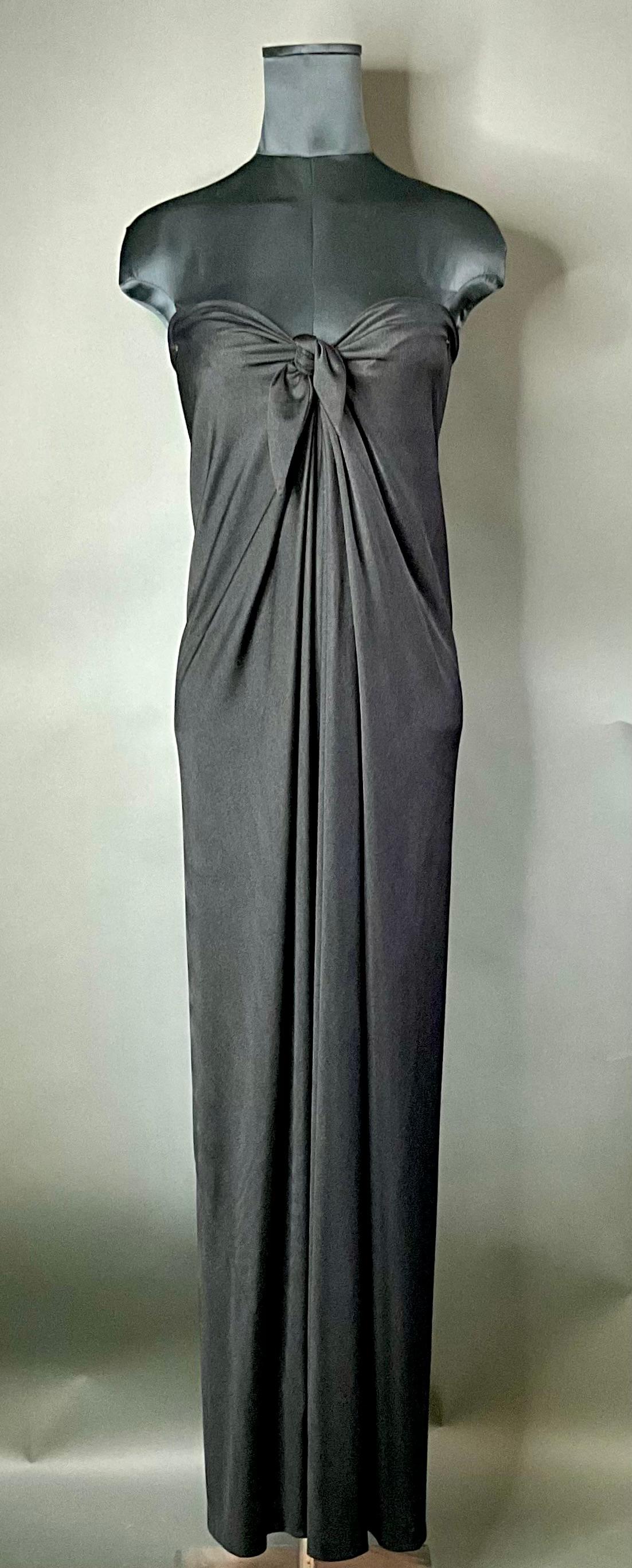 Un Vestido Columna Halston Vintage con Lazo Delantero es una pieza que capta la esencia de la alta costura de los años setenta. Halston, renombrado diseñador estadounidense, era famoso por sus diseños minimalistas pero glamurosos, que le