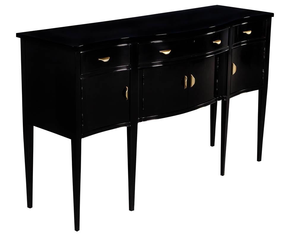 Vintage black high gloss sideboard buffet by Hickory Chair. Classic and timeless English Hepplewhite styled sideboard with a hand polished piano black finish and deluxe antique brass hardware. Quality construction, dovetail drawers, solid wood
