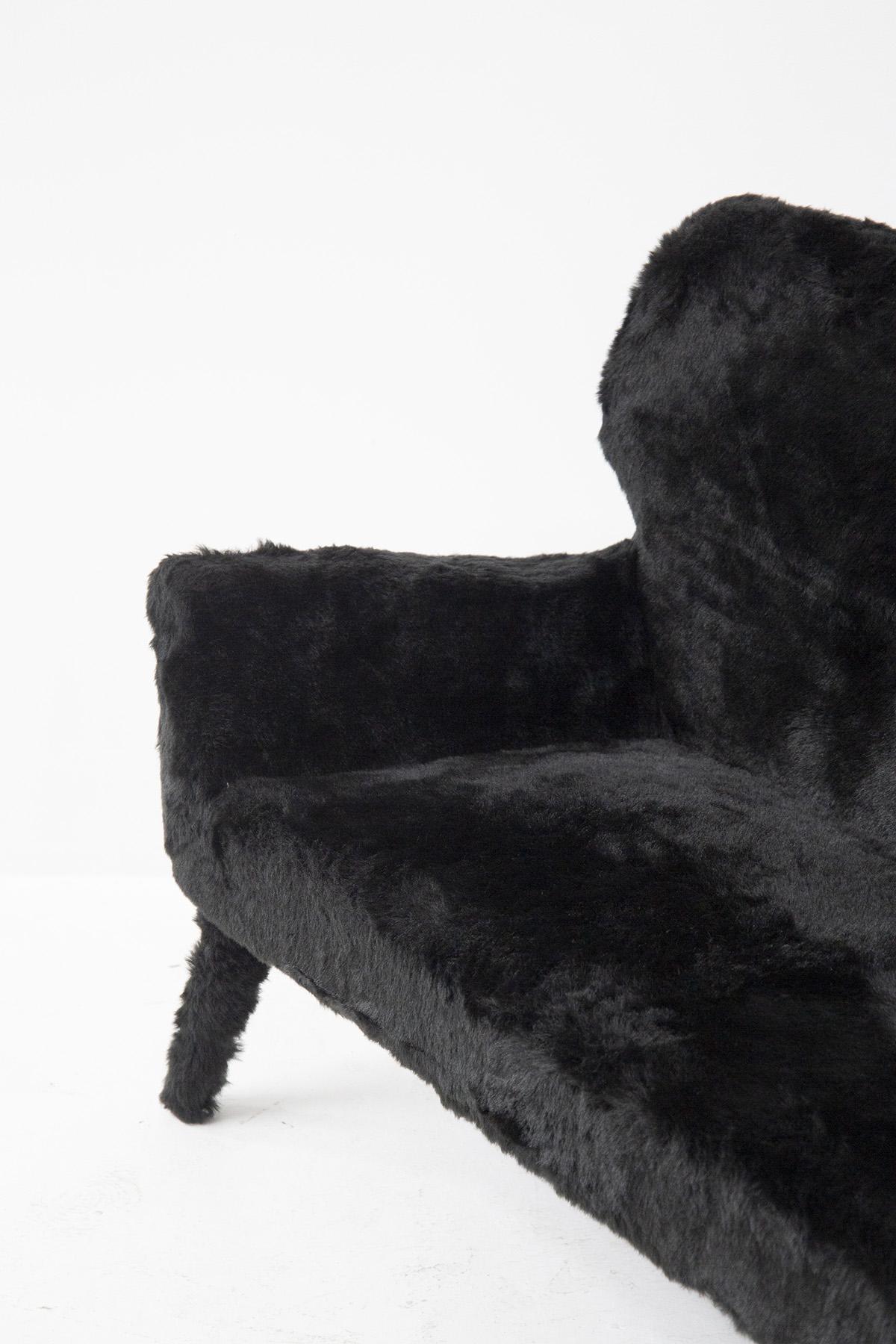 Gorgeous vintage sofa made in the 1950s, Italian manufacture.
The sofa is totally covered in black faux fur, very whimsical.
The shapes are very simple and sinuous. There are 4 feet for support also covered in fur. The armrests create a gentle