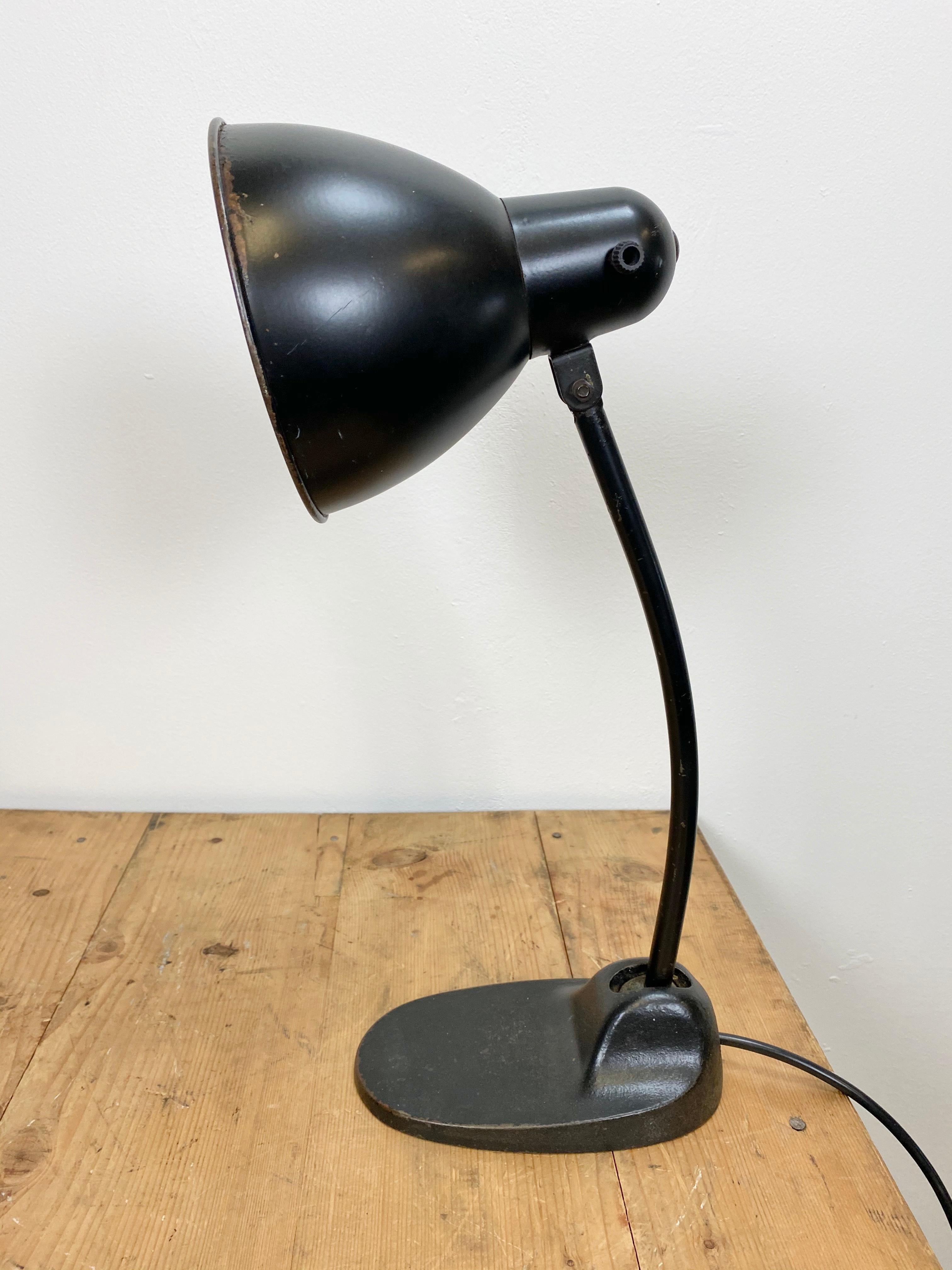 This Bauhaus industrial desk lamp was made during the 1930s. The lamp has black metal shade, silver interior, black iron base and arm with two adjustable joints. It features the socket for E27 lighbulbs with a rotary switch and new wire. Diameter of