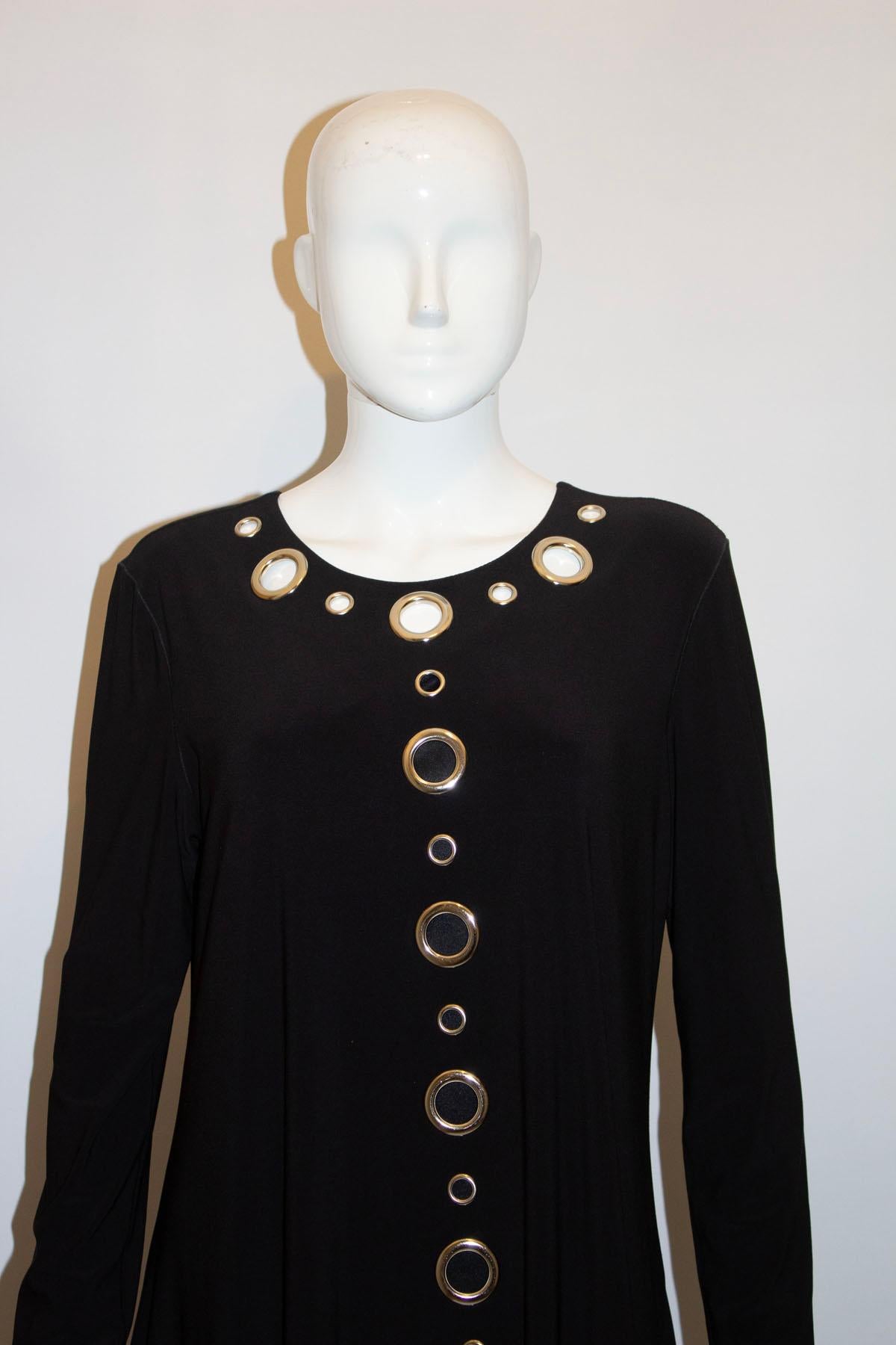 Ein lustiges und leicht zu tragendes schwarzes Jerseykleid  mit Loch-Detail. Das Kleid hat einen runden Ausschnitt und ist A-Linie in einem schweren Jersey-Stoff und hängt schön.
Maße Oberweite bis zu 40'', Länge 36''
