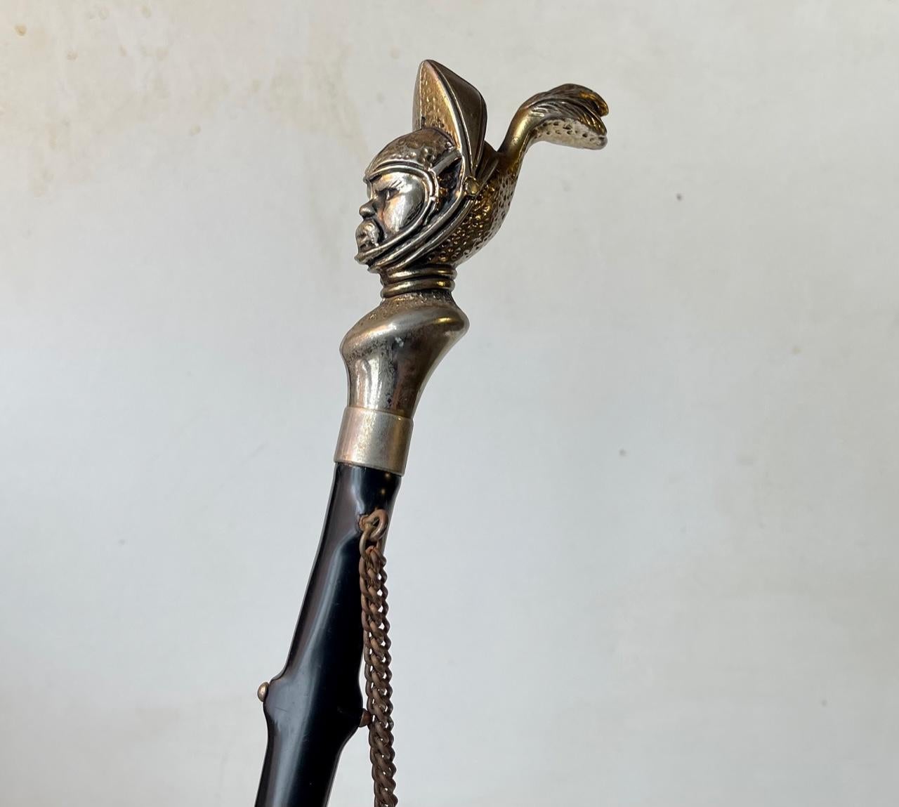 Unusual long wall hung shoe horn. Nickel plated black Knight handle set on a stylized black rod with rose thorns. European made circa 1950 - Germany. Measurements: H: 54 cm. The 'shoe horn' itself measures: 17x4x2 cm.