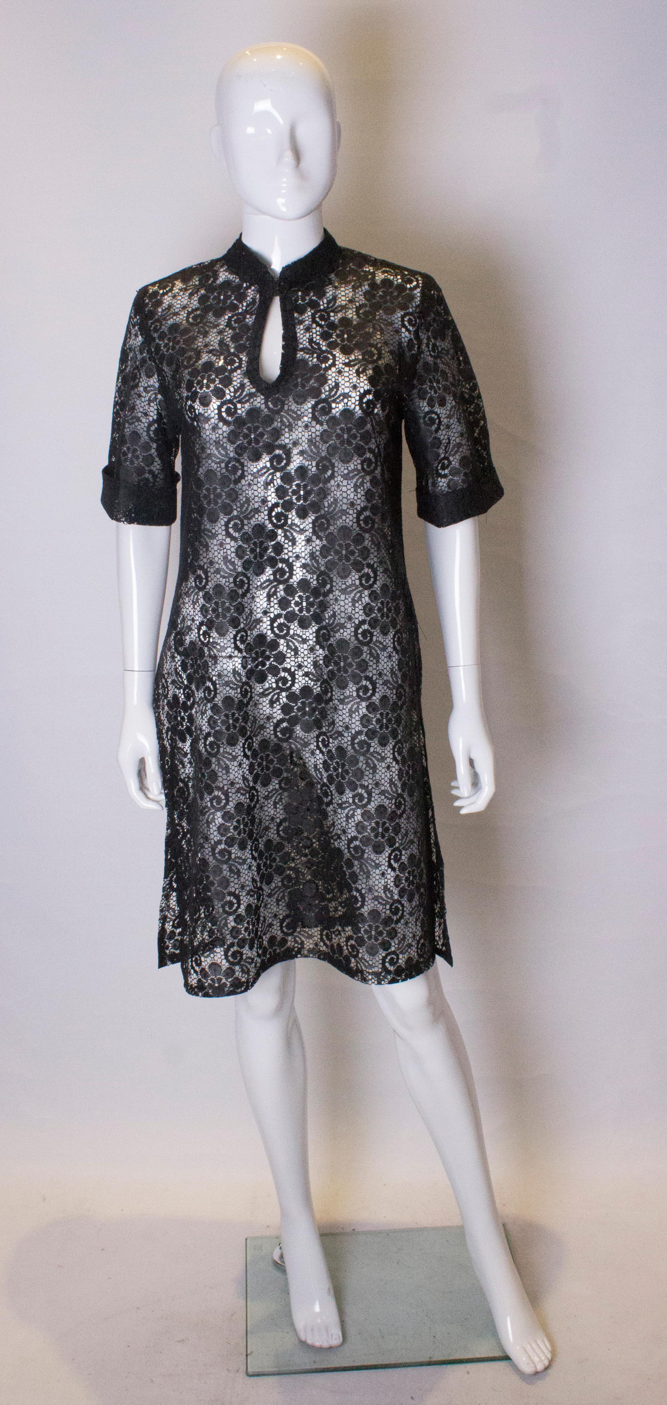 A chic and easy to wear vintage black lace tunic. The tunic is collarless with a one button opening at the front.  It has short sleeves and a 20'' slit on either side.