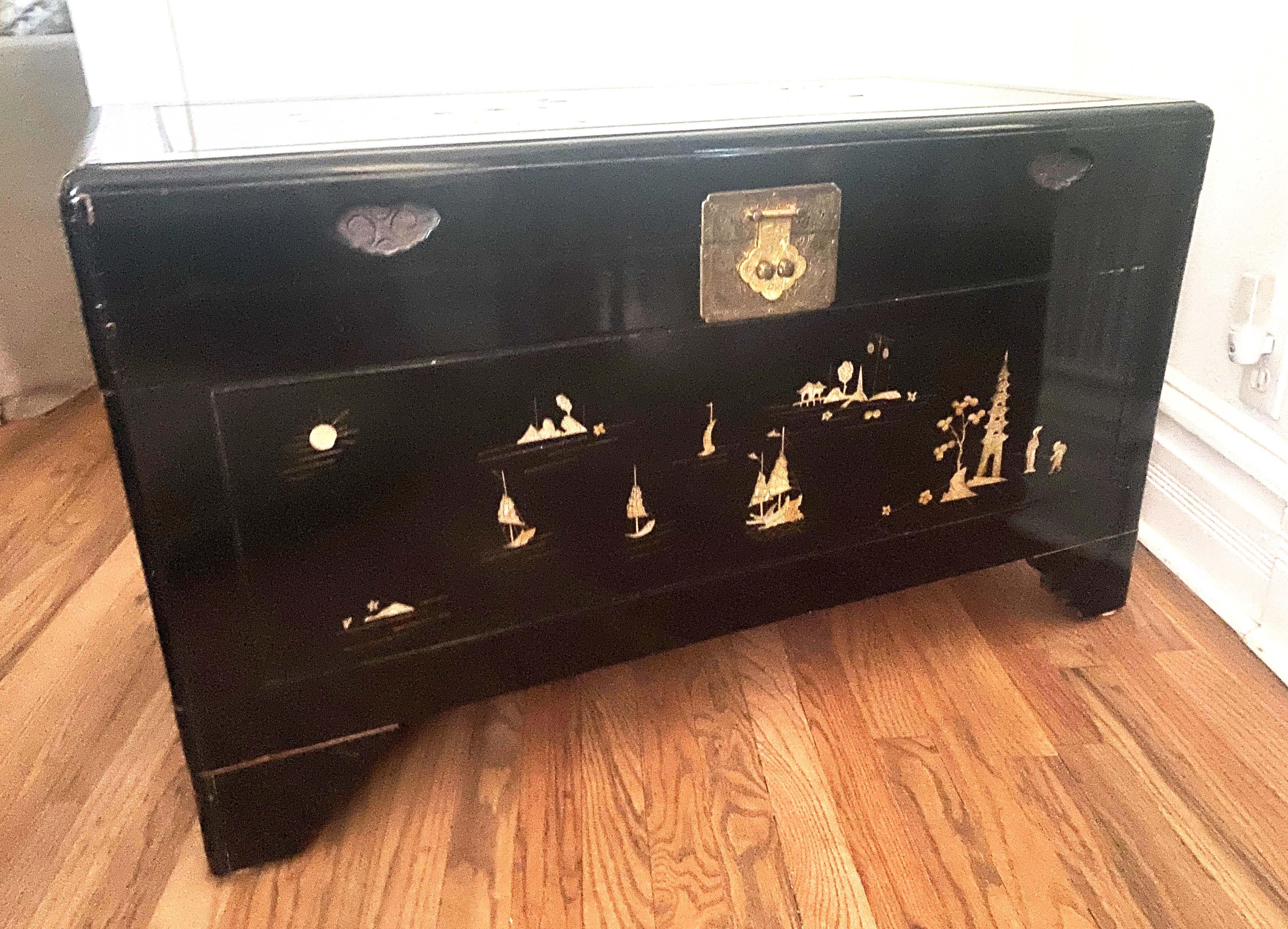 Vintage Black Lacquer Chinoiserie Wedding Chest With Mother of Pearl Inlay mid - late 20th c. The mother of pearl scenes feature unique sailboats that change on every side with natural elements and floral details added throughout. It is constructed