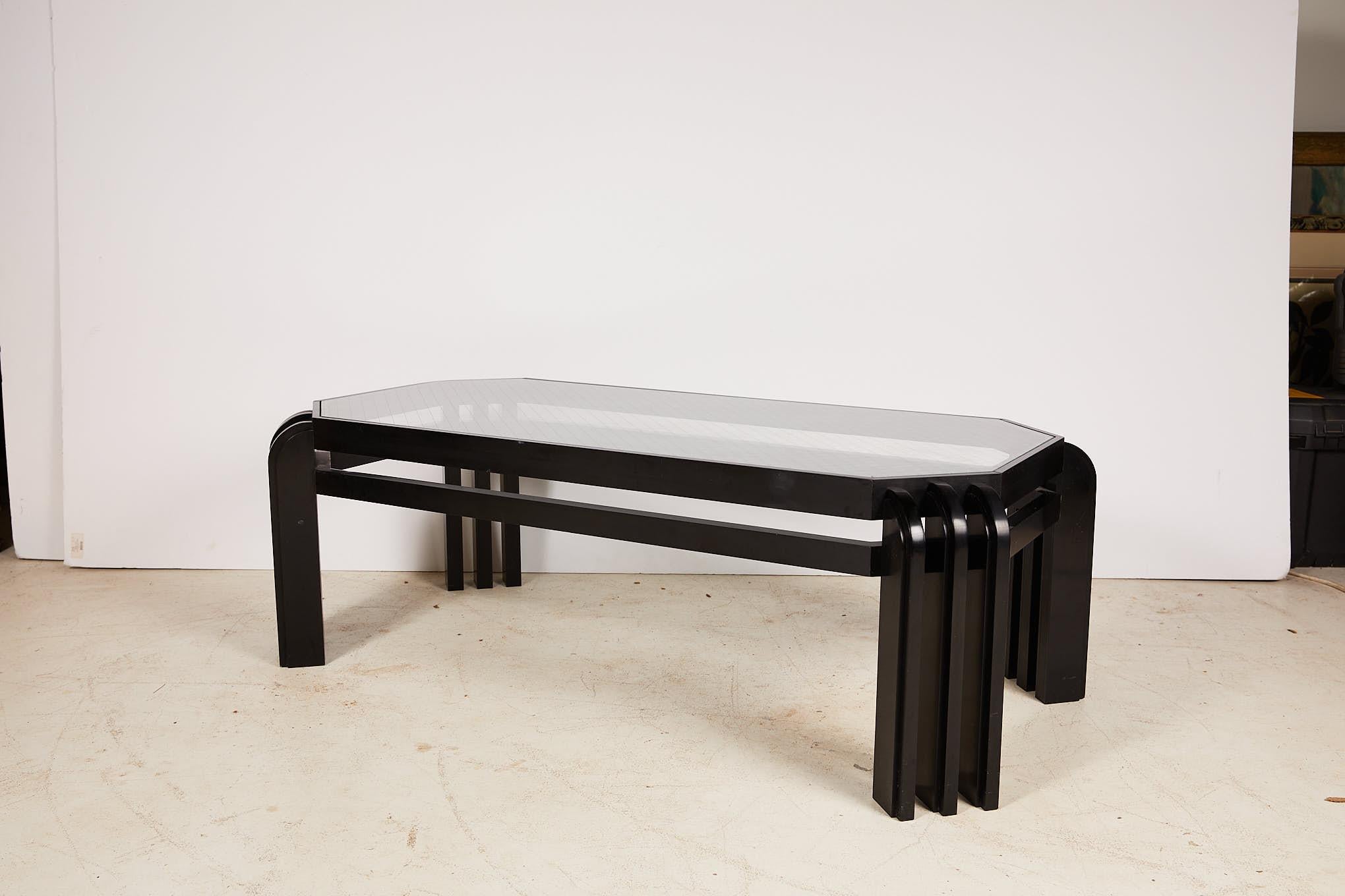 Sleek 20th century rectangular cocktail table in a black lacquer finish with tapered corners and an inset wired glass top having lattice pattern.