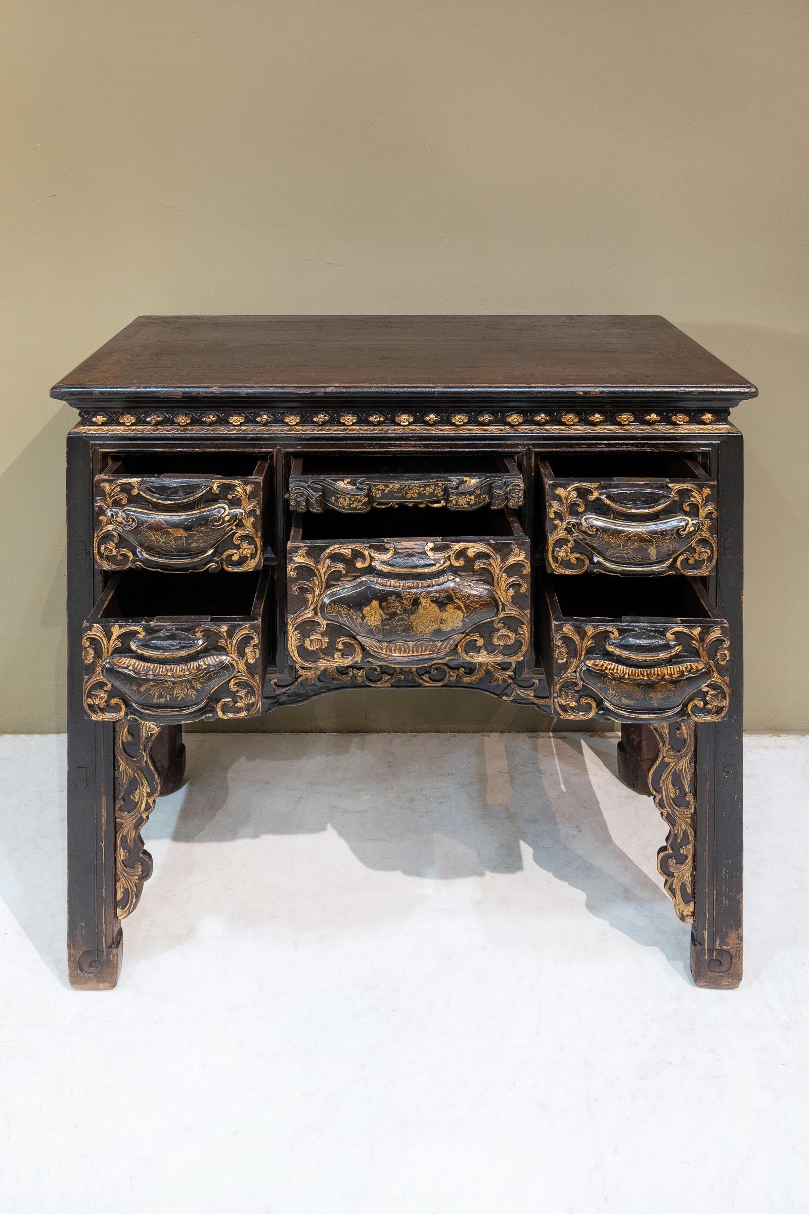 A beautiful black lacquered table with gold painting from Chaozhou province, China. The bulbous panels on the front of the drawers and the black & gold colour combination are very typical designs of the Chaozhou region.
 
The designs on the