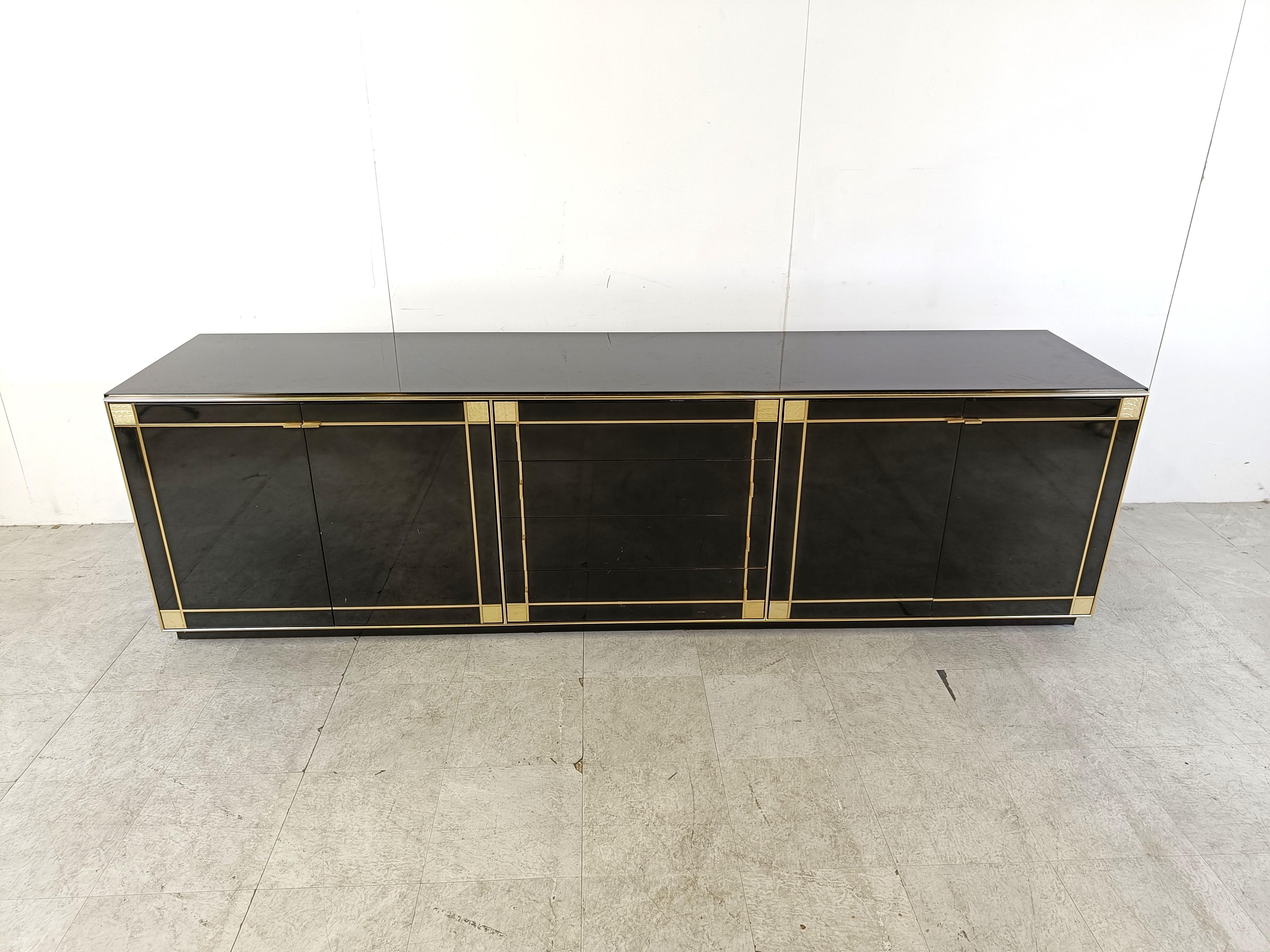 Luxuriöses Sideboard aus schwarzem Lack, Perlmutt und Messing von Pierre Cardin für Roche Bobois, bestehend aus 4 Türen und 4 Schubladen, die viel Stauraum bieten.

Die Messinglinien, die das Sideboard einrahmen, bilden einen schönen Kontrast zum