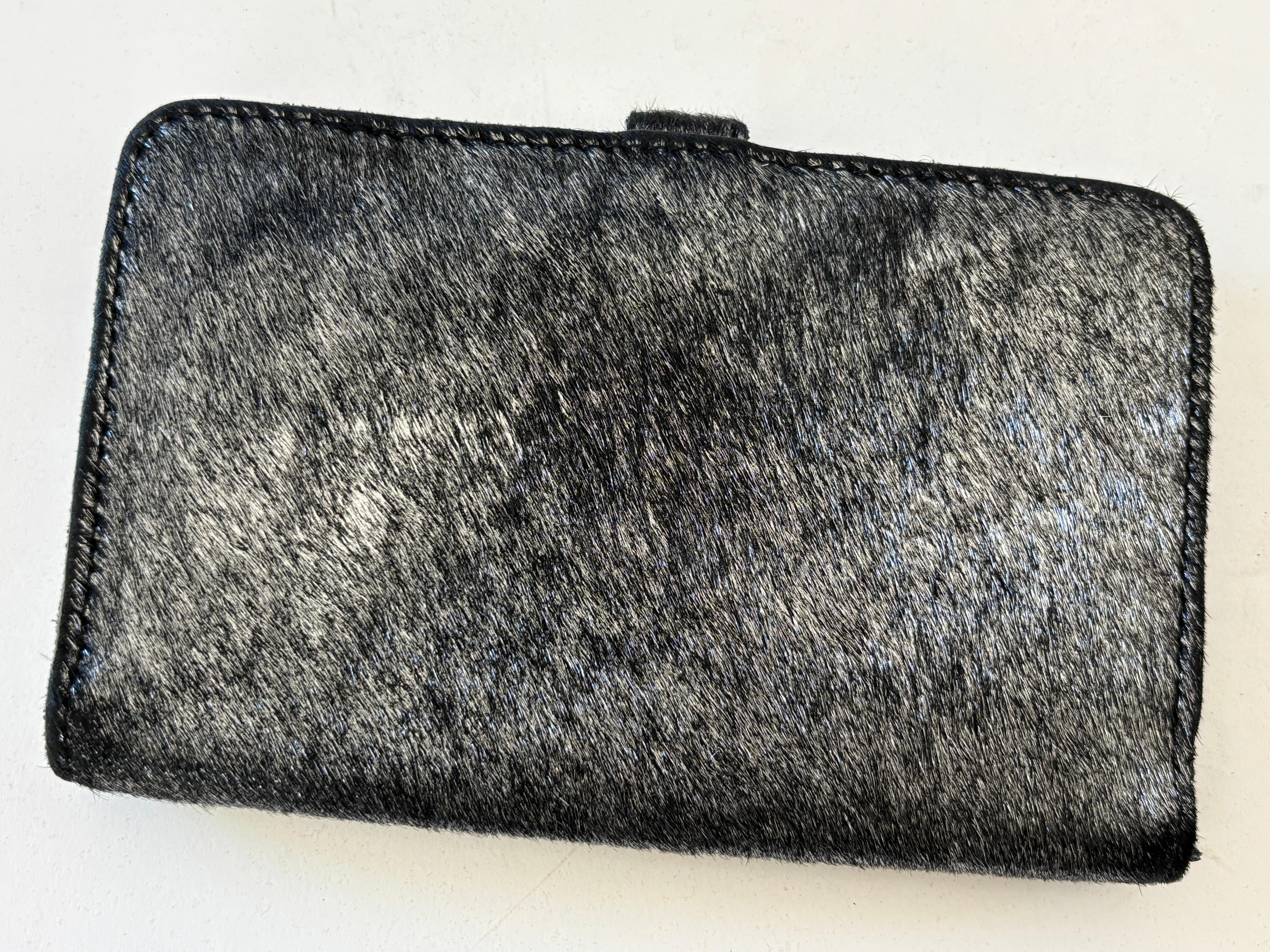Cartera vintage Linea Pelle de pelo de poni.
Te cabrán varias cosas esenciales gracias a las diferentes ranuras que tiene para tarjetas y dinero en efectivo y un pequeño bolsillo para el cambio.
Cuero negro y pelo de poni.
Materiales: Cuero y Pelo