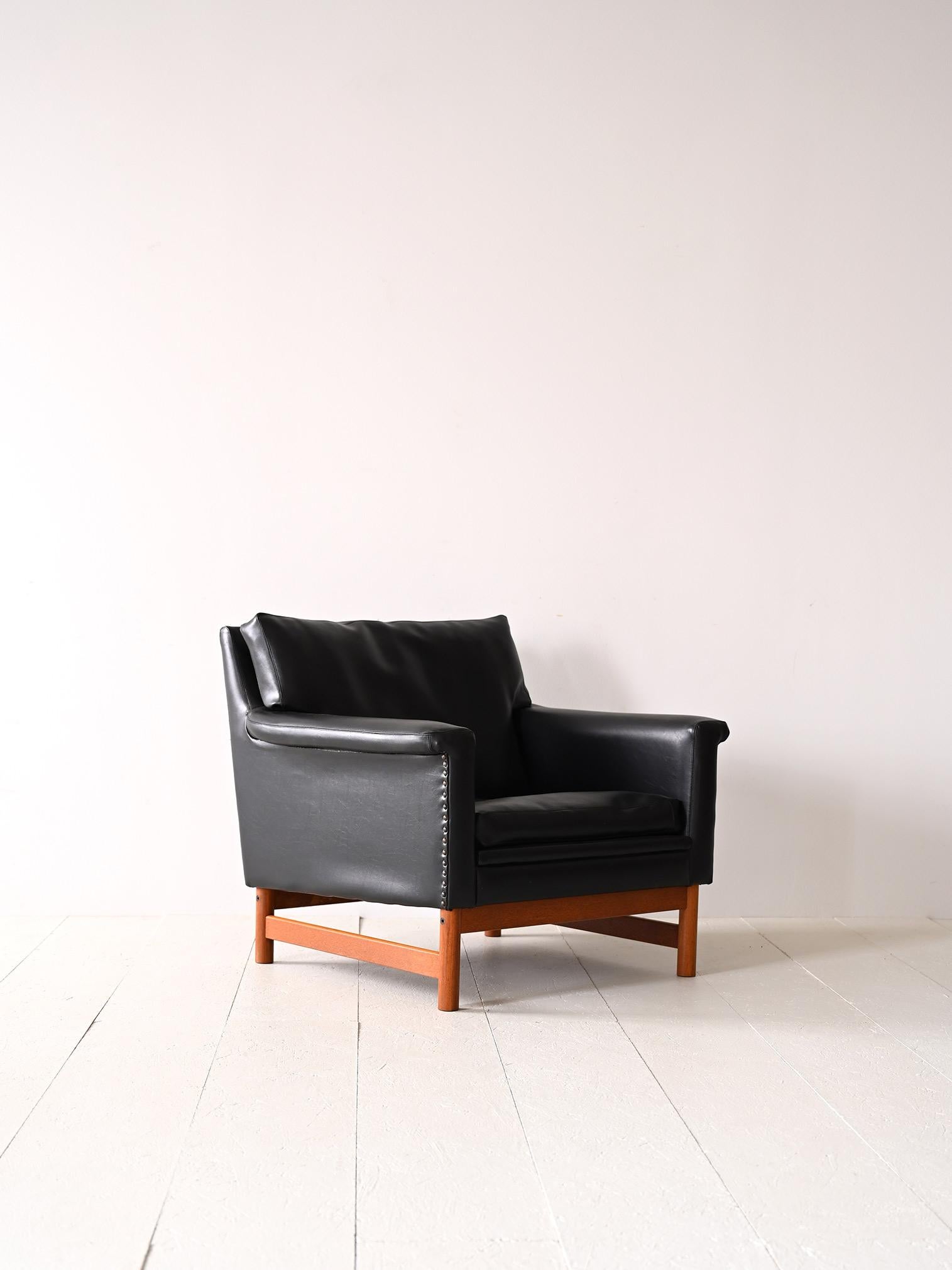 Fauteuil scandinave des années 1960.

Un meuble ancien moderne aux lignes carrées et contemporaines. Formé d'une base en bois sur laquelle repose l'assise rembourrée doublée de similicuir noir. L'état des ressorts et du rembourrage est en bon état