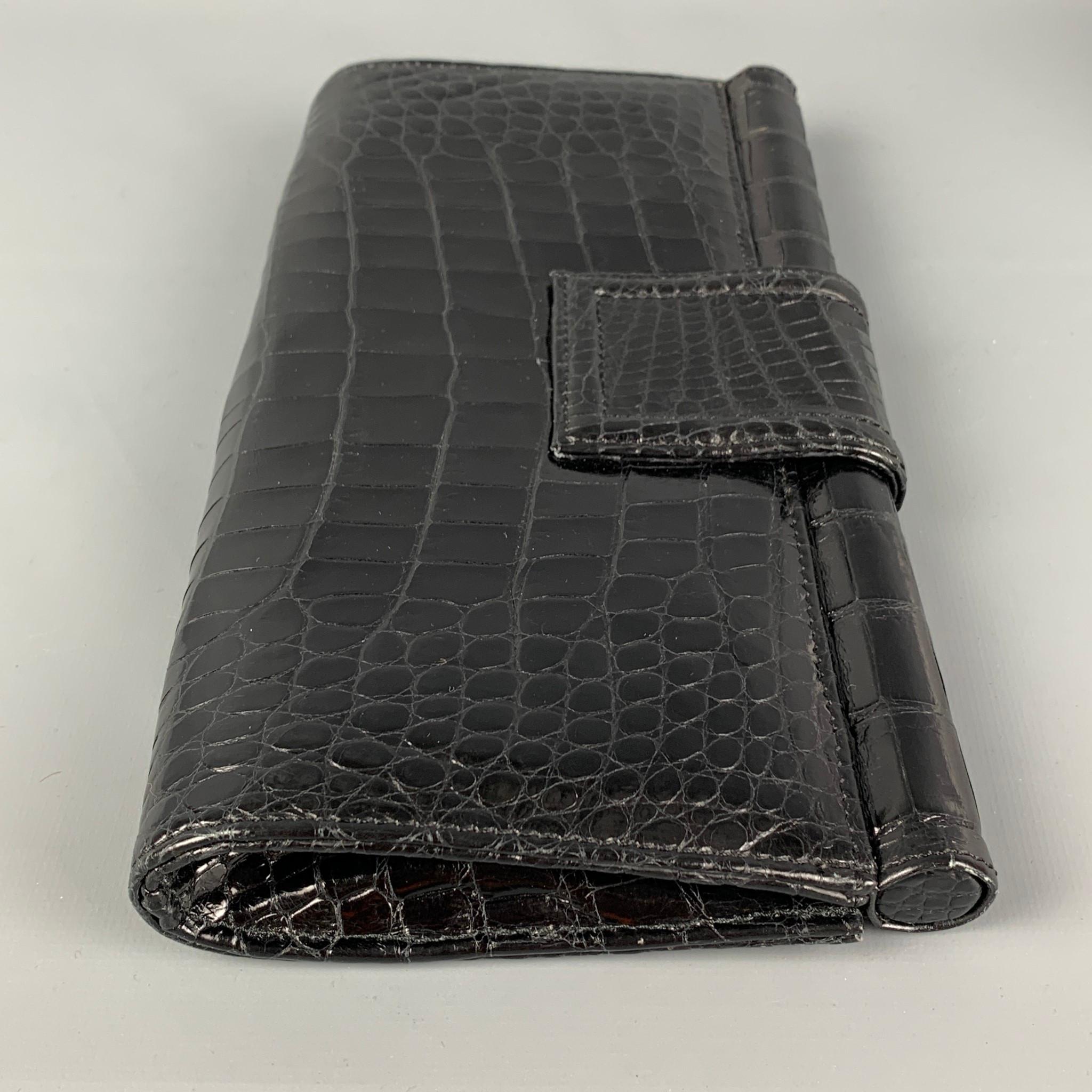 VINTAGE clutch comes in a black crocodile leather featuring a inner pocket and a magnetic closure. 

Good Pre-Owned Condition.

Measurements:

Length: 9.75 in.
Height: 5.5 in.