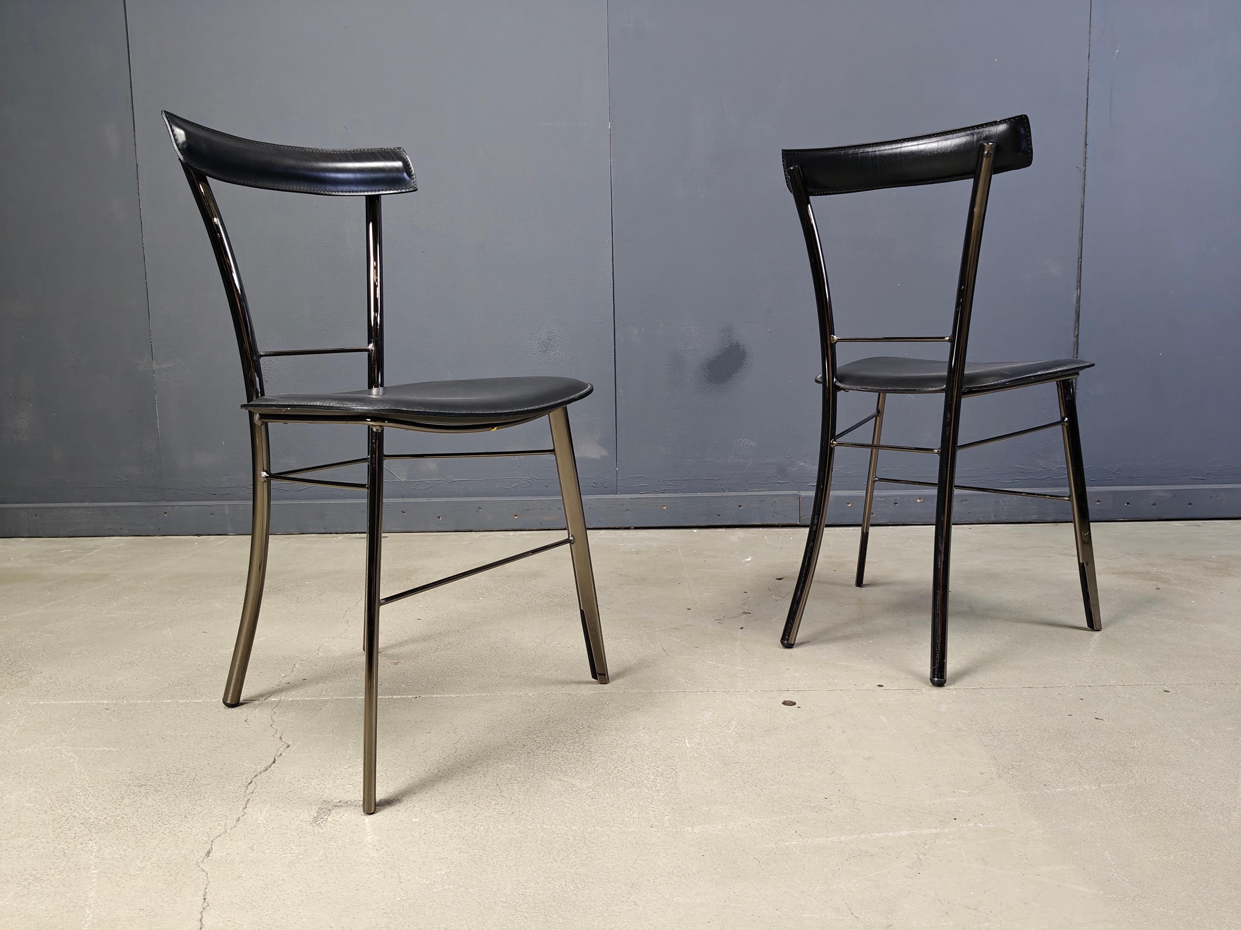 Ensemble de 4 chaises de salle à manger italiennes constituées d'une structure en métal noir et d'un revêtement en cuir noir sur les sièges et les dossiers.

Design/One élégant et classique 

Très bon état.

Années 1980 - Italie

Dimensions