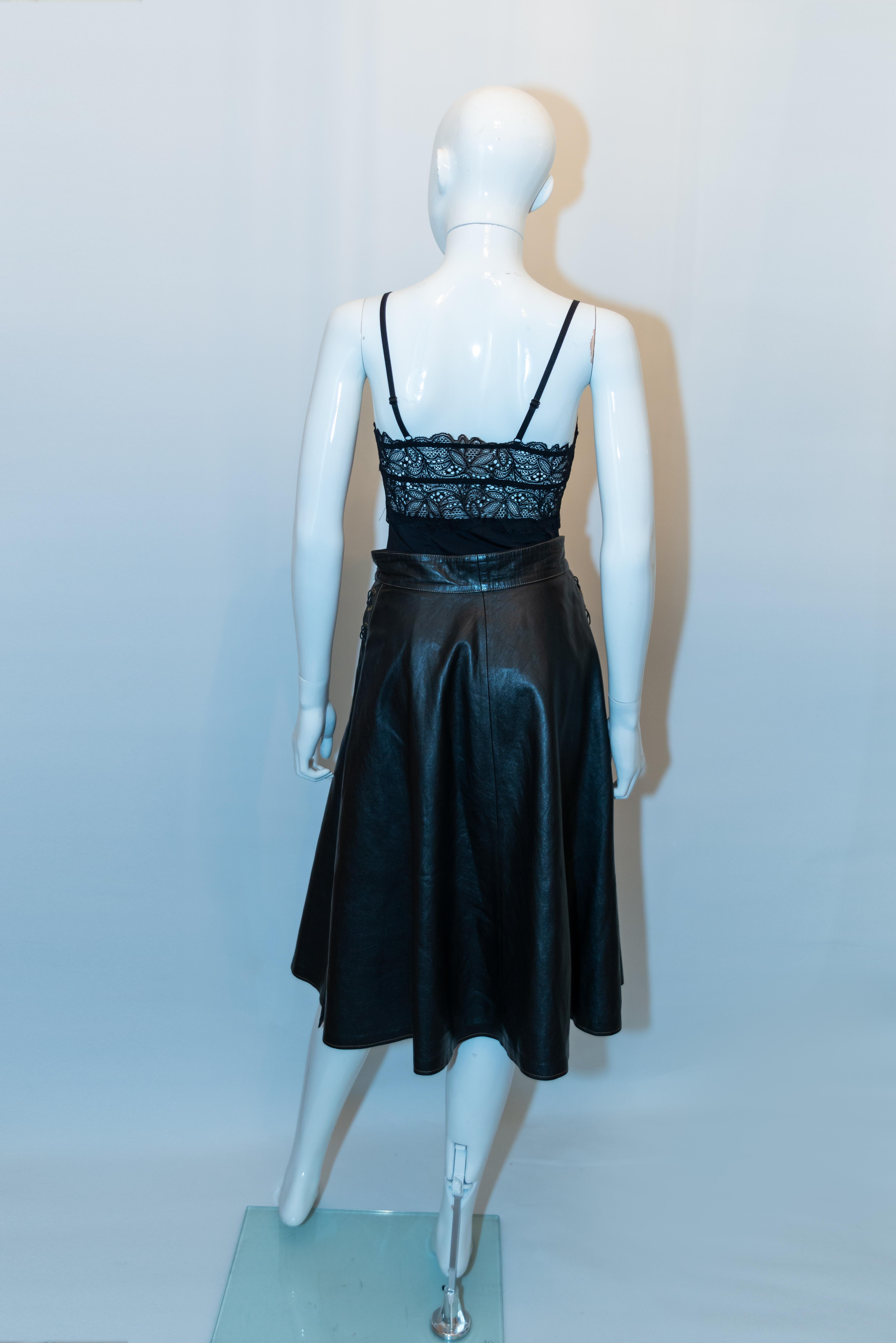 A fun and easy to wear vintage leather skirt by Larry Long. In a black leather with lace up detail on both sides, together with a 12 '' slit on either side.  The  skirt has a button front opening and pocket on either side.  Measurements: waist 25'',
