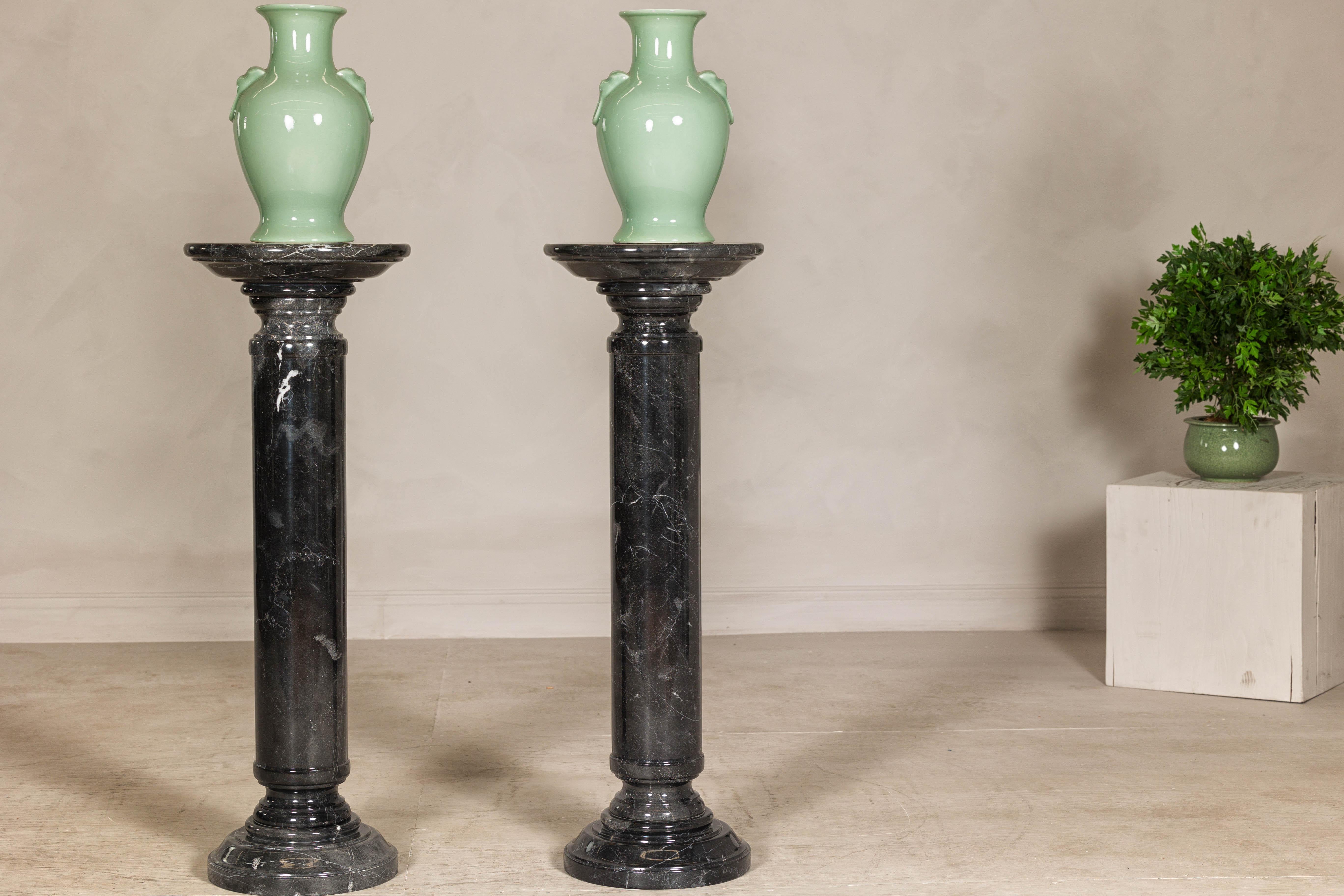 Ce piédestal colonne en marbre noir vintage et veiné de blanc, d'une hauteur impressionnante de 40 pouces, est une pièce d'apparat idéale pour tout intérieur. Son design élégant présente un sommet arrondi, parfait pour exposer une sculpture, un vase