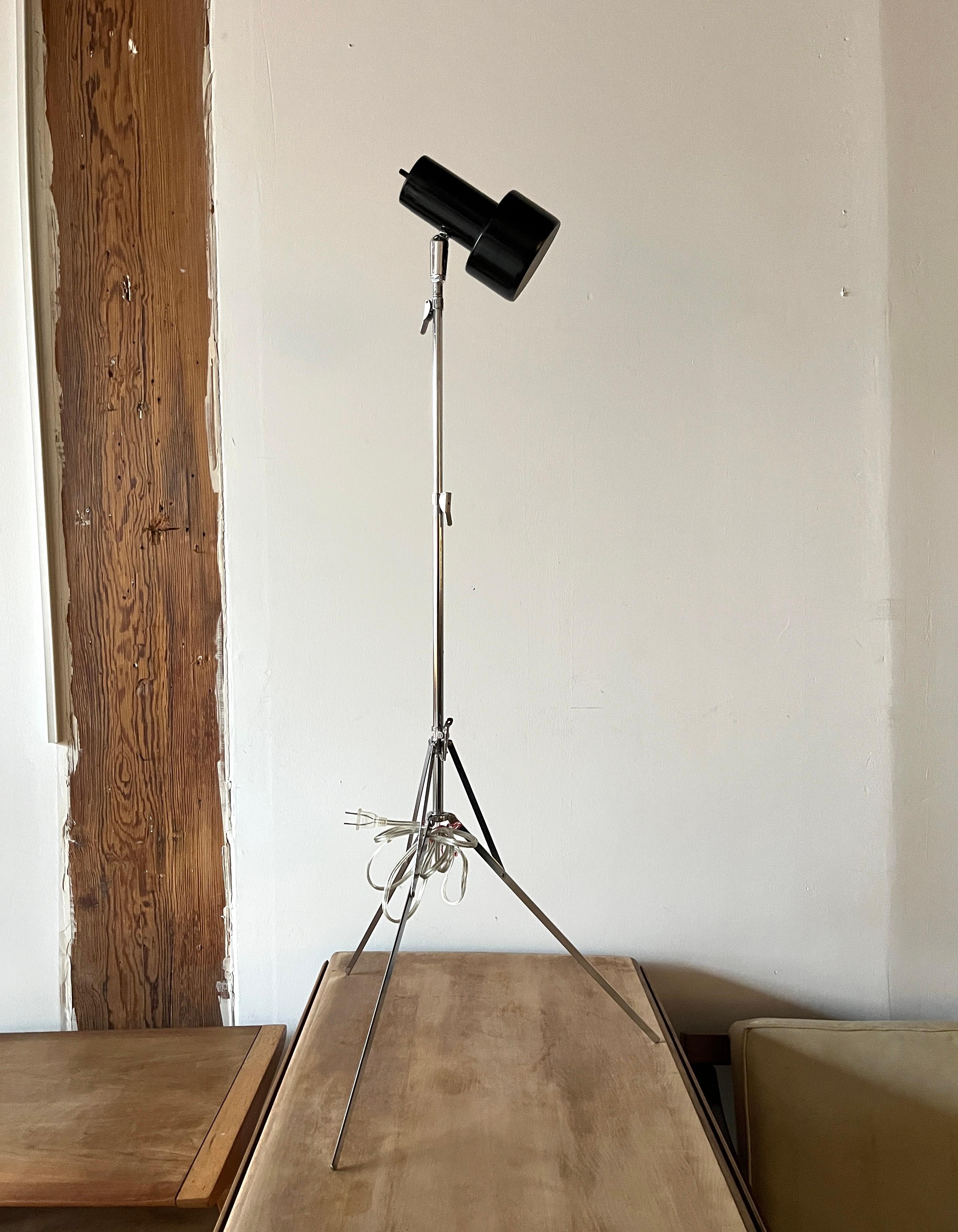 Pristine chrome telescoping tripod floor lamp with black shade. Great for a minimalist decor. It does not take much space thanks to its delicate legs and telescopic structure. 

It adjusts to over 58