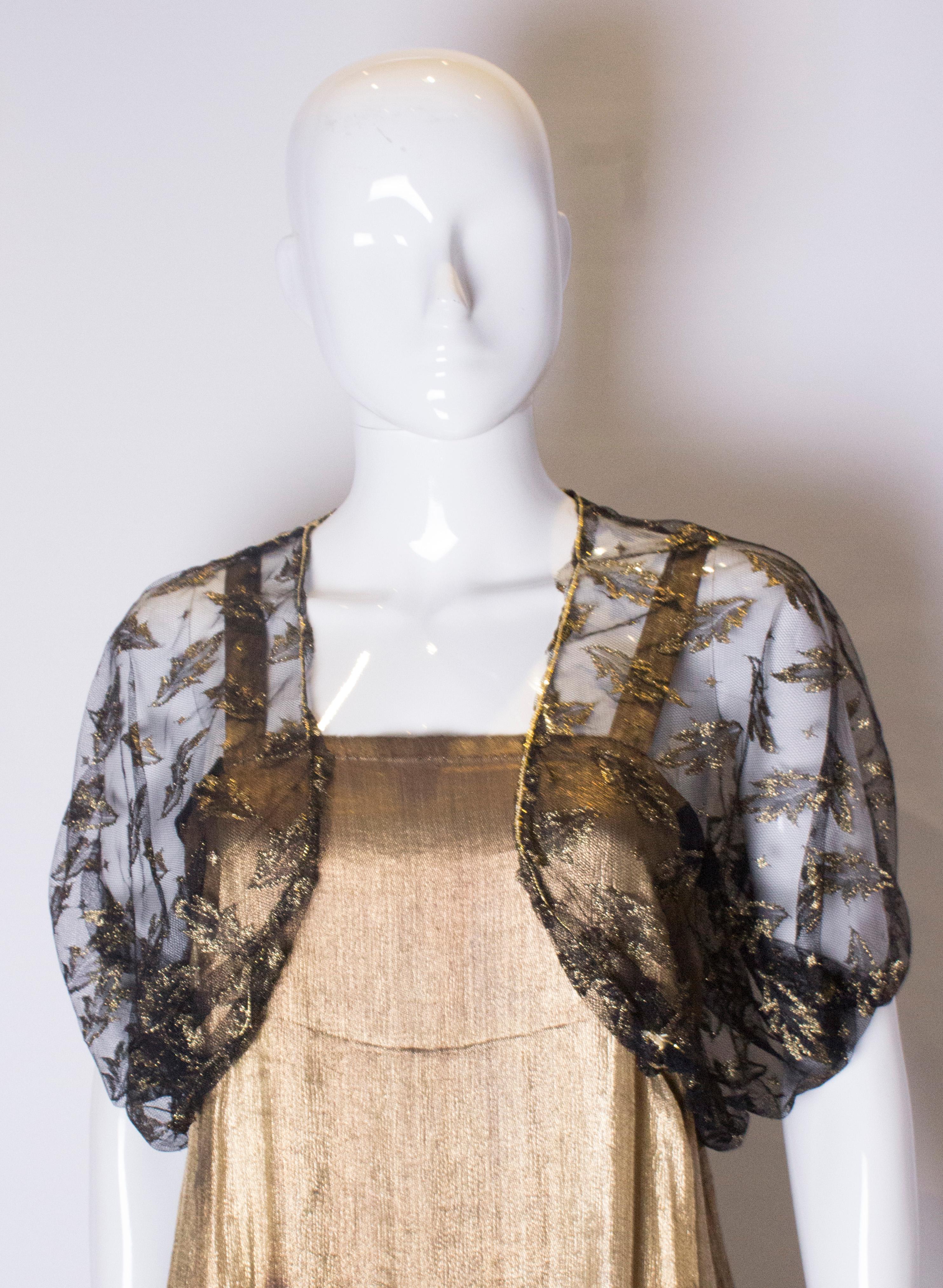 A chic black net bolero with gold leaf design. It has elastic at the hem, and a gold band on the shoulder and edge. Measurements; Bust up to 36'', length 15''