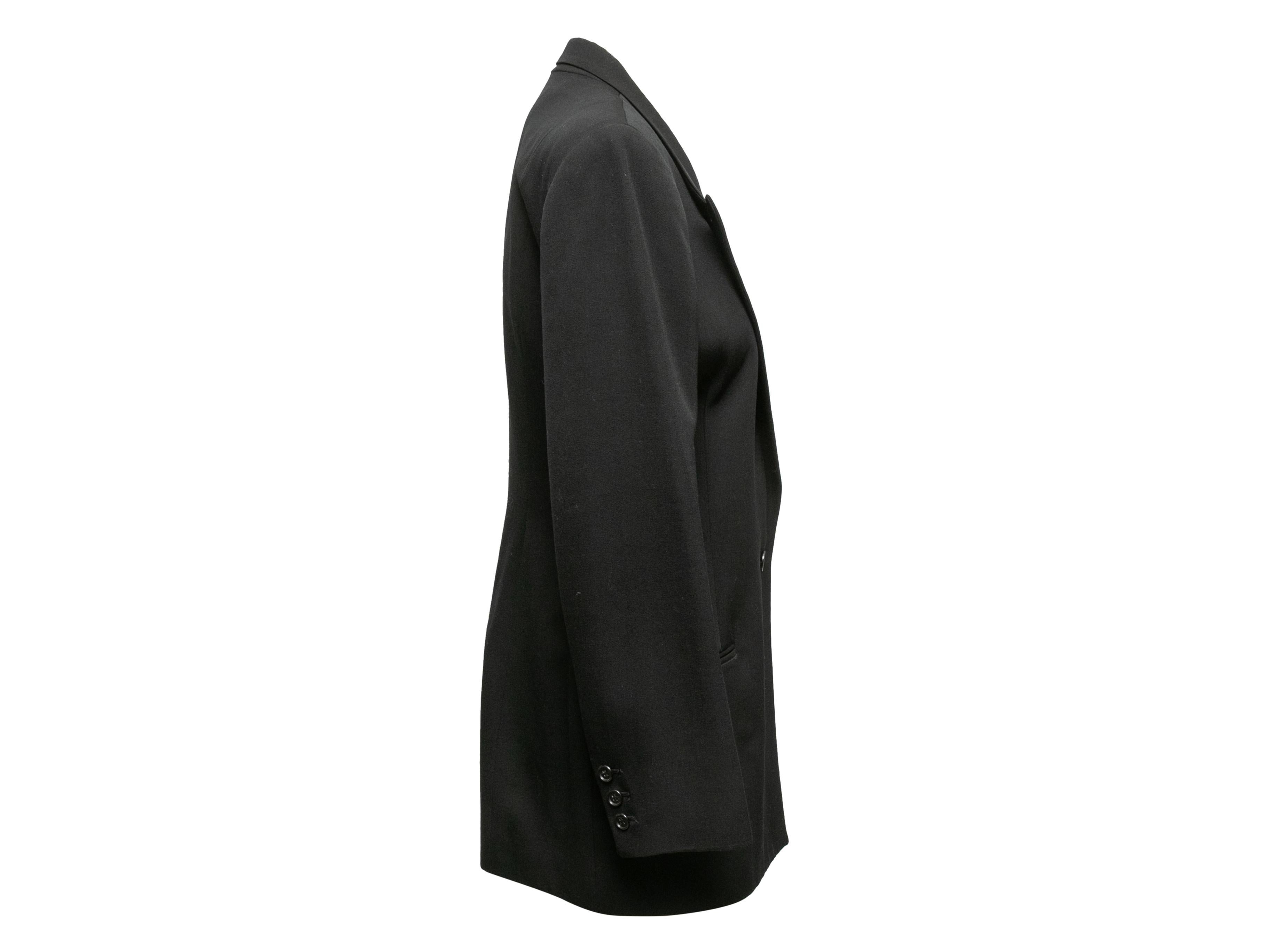 Vintage black wool blazer by Norma Kamali. Circa 1980s. Peaked lapel. Three welt pockets. Single button closure at front. 32