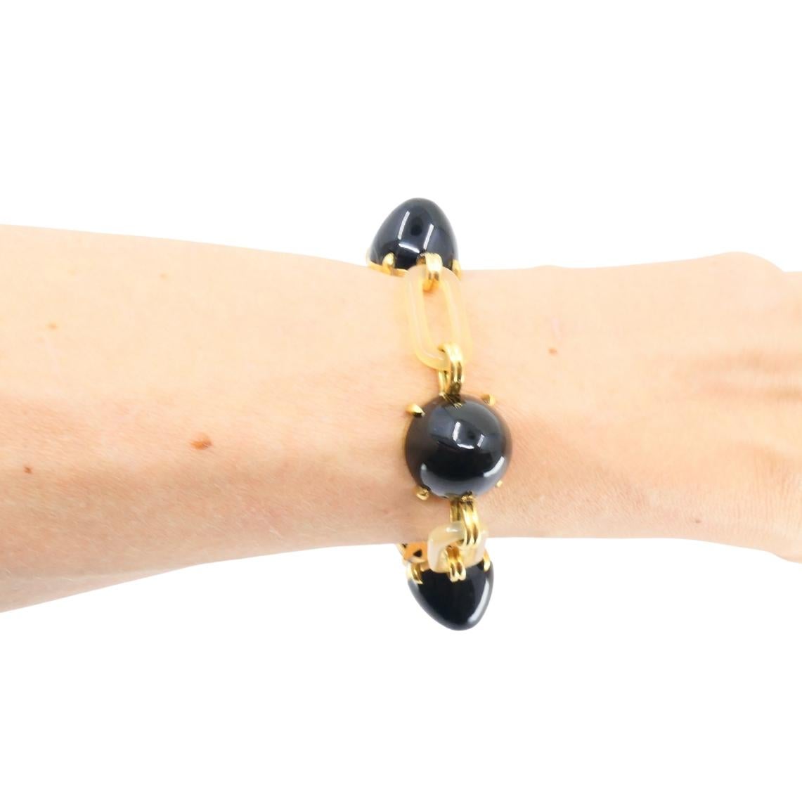 Esta pulsera vintage presenta una combinación de cuentas de ónice negro, eslabones de baquelita blanca y herrajes de oro amarillo de 14 quilates. El diseño alterna entre seis conos redondos de ónice negro muy pulido y eslabones rectangulares