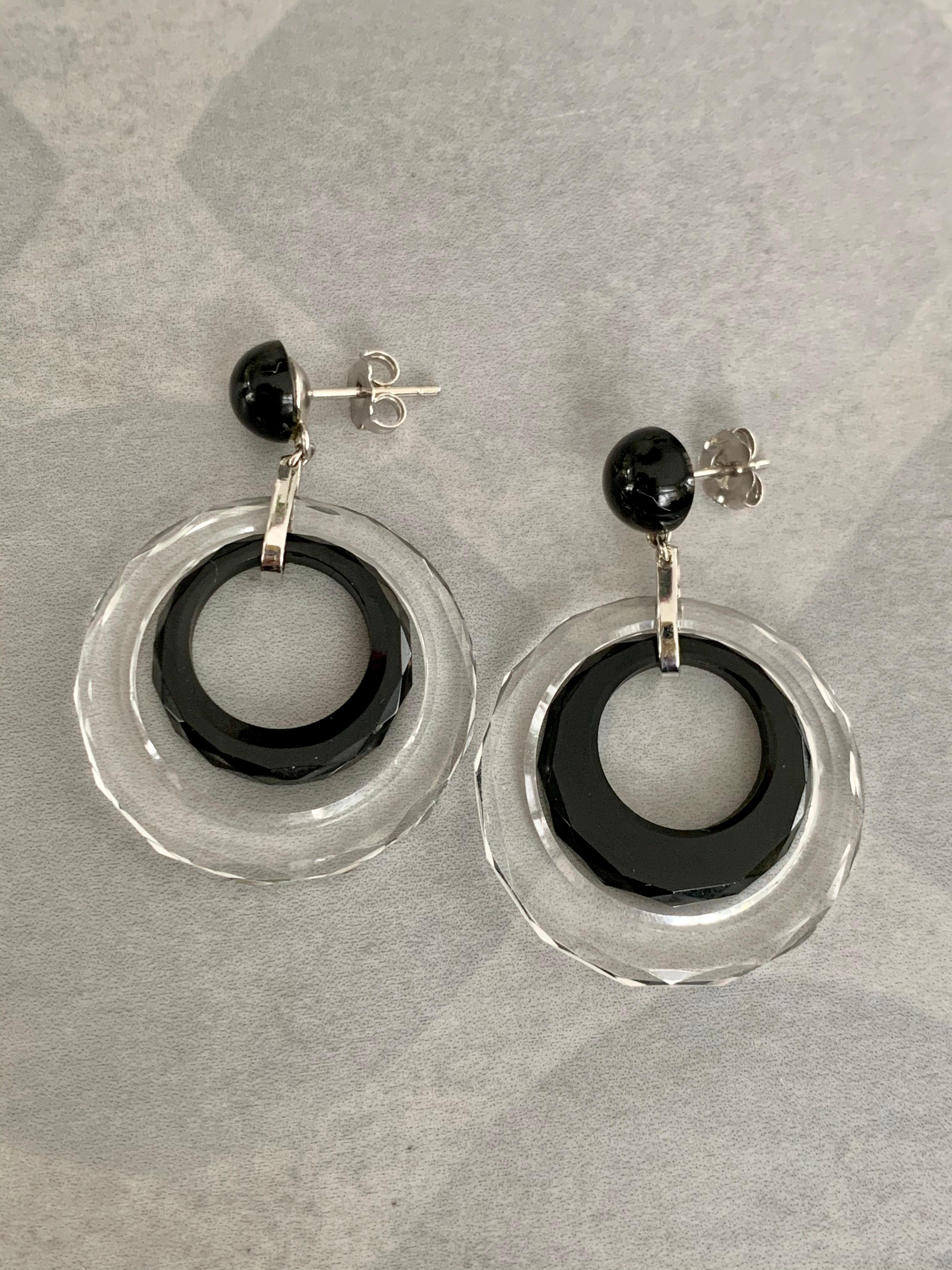 These very fun and modern looking earrings, feature an inner hoop of black Onyx, surrounded by a hoop of Crystal.  Black Onyx round stone is also featured on the post of each earring.  Posts and connecting loop are both 14 karat white Gold. 

Size: 