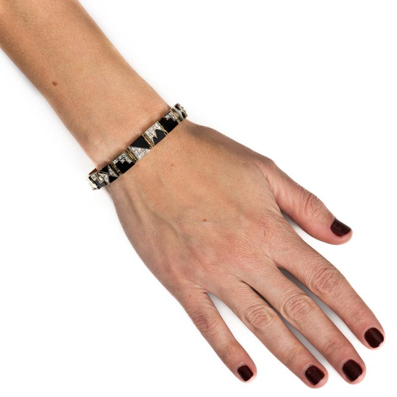 This is a very unique vintage bracelet featuring black onyx set in 14 karat yellow gold with diamonds layered on top set in 14 karat white gold. There are five different designs for a distinctive look. Box with safety clasp closure. 
Measurements: