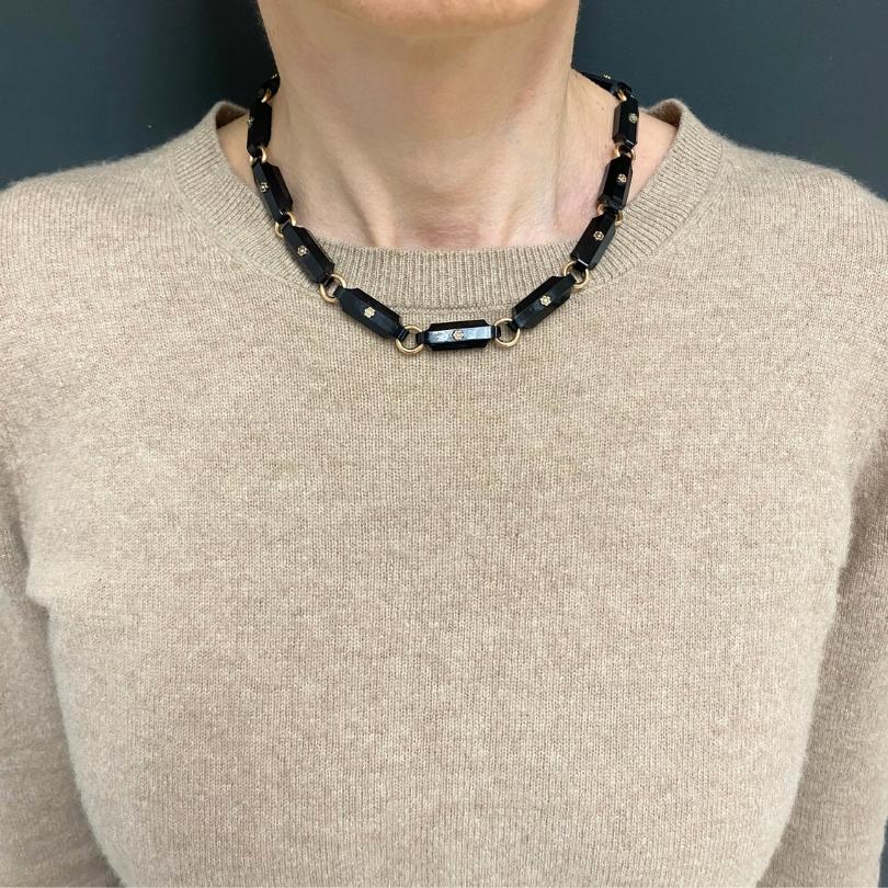 Geometrische Halskette aus schwarzem Onyx im Vintage-Stil, mit Gliedern aus 14-karätigem Gold und Blumenmuster.u2028Jedes Onyxglied ist in eine abgeschrägte, längliche Form geschnitten. In der Mitte jedes Onyxstabs sitzt eine kleine Blume. Die Stege