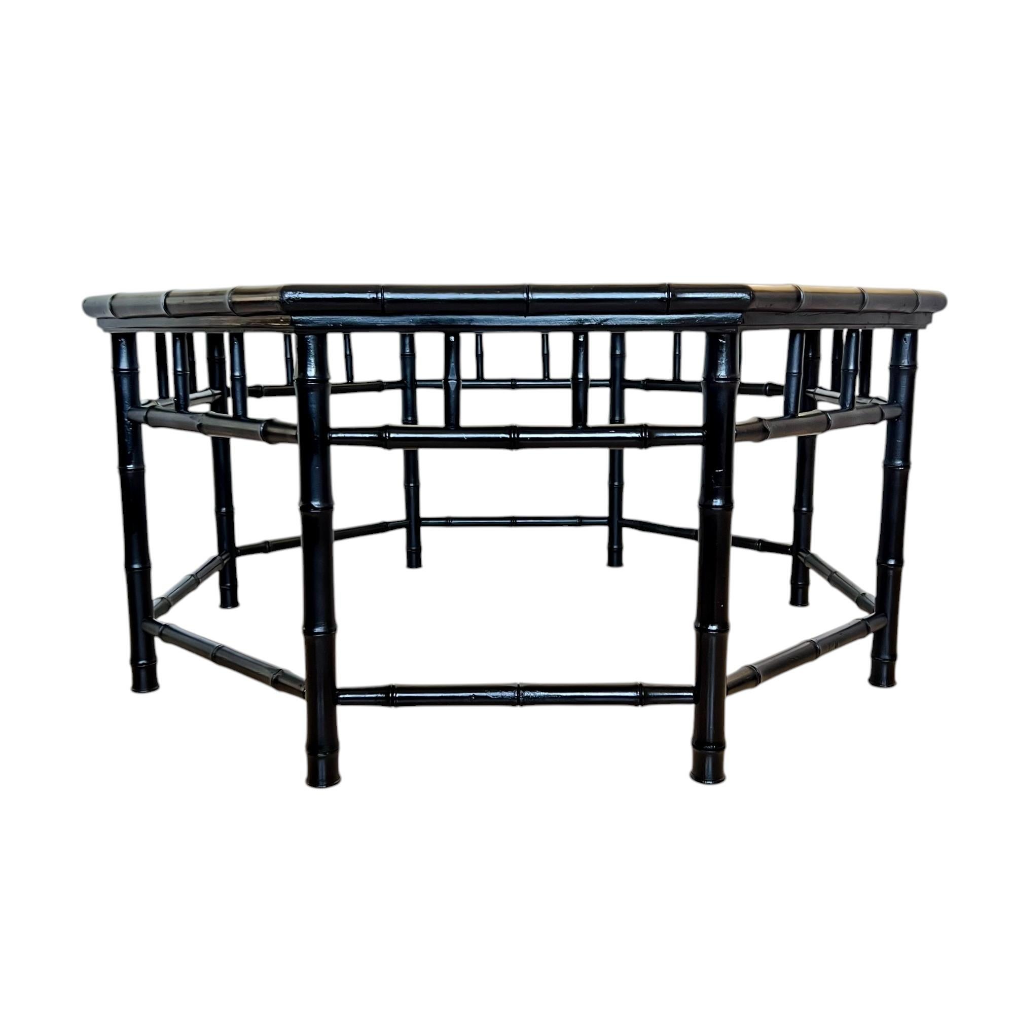 This vintage newly painted wood octagon coffee or center table features an inset glass top with a double beveled edge, a doweled showcase apron and eight turned legs connected by stretchers. Its Palm Beach regency style is accentuated with faux