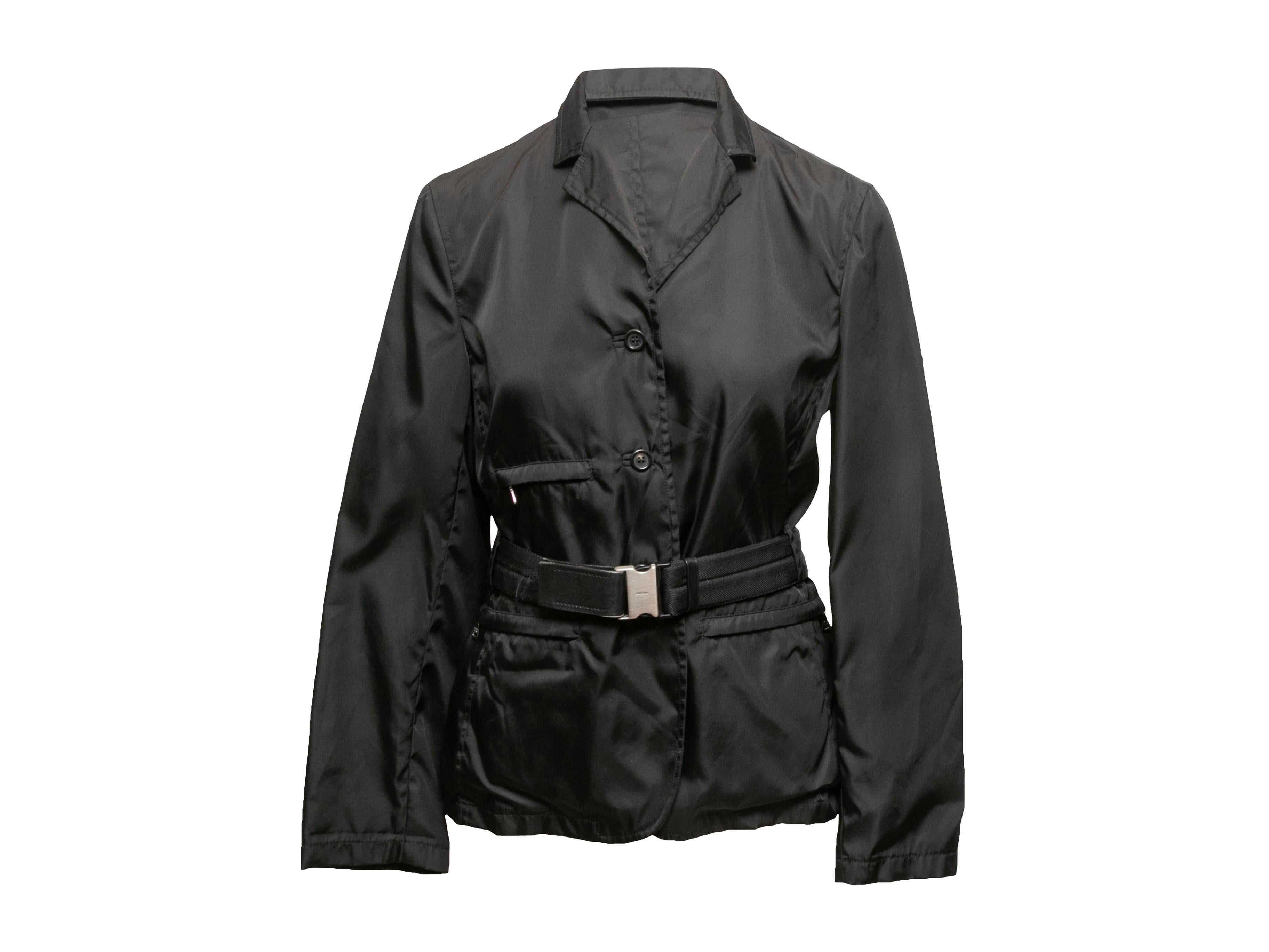 Product Details: Vintage black nylon belted jacket by Prada. Circa 1990s. Notched lapel. Welt pockets. Button closures at center front. 33