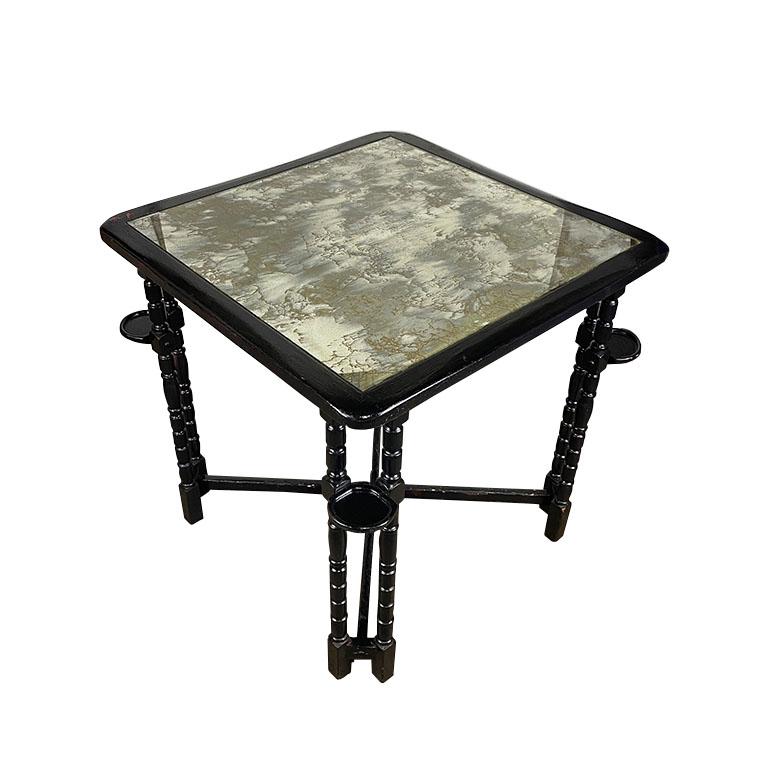 An ebonized black square game table with mirrored top, and drink or cigar holders. This beautiful vintage piece will be a fabulous way to host your weekly mahjong, bridge, or card game. Game tables are a nod to a pastime that we can't get enough of.