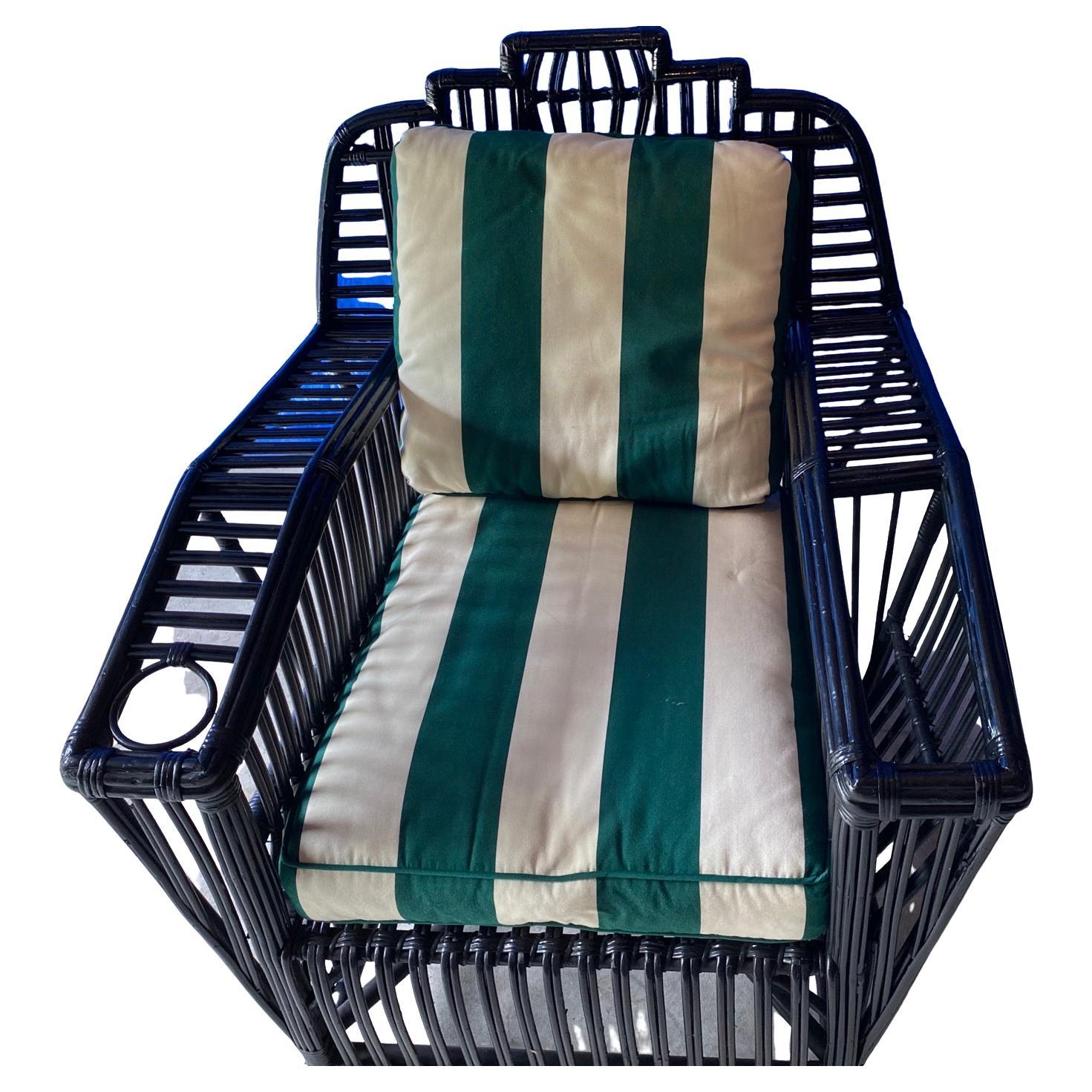 Remembrance of the glamour days at Newport or Palm Beach, this grand scale stick wicker arm chair with stripped cushion making it an inviting to enjoy a leisurely day with a drink and reading a book. A hole in one arm for a drinking glass and a