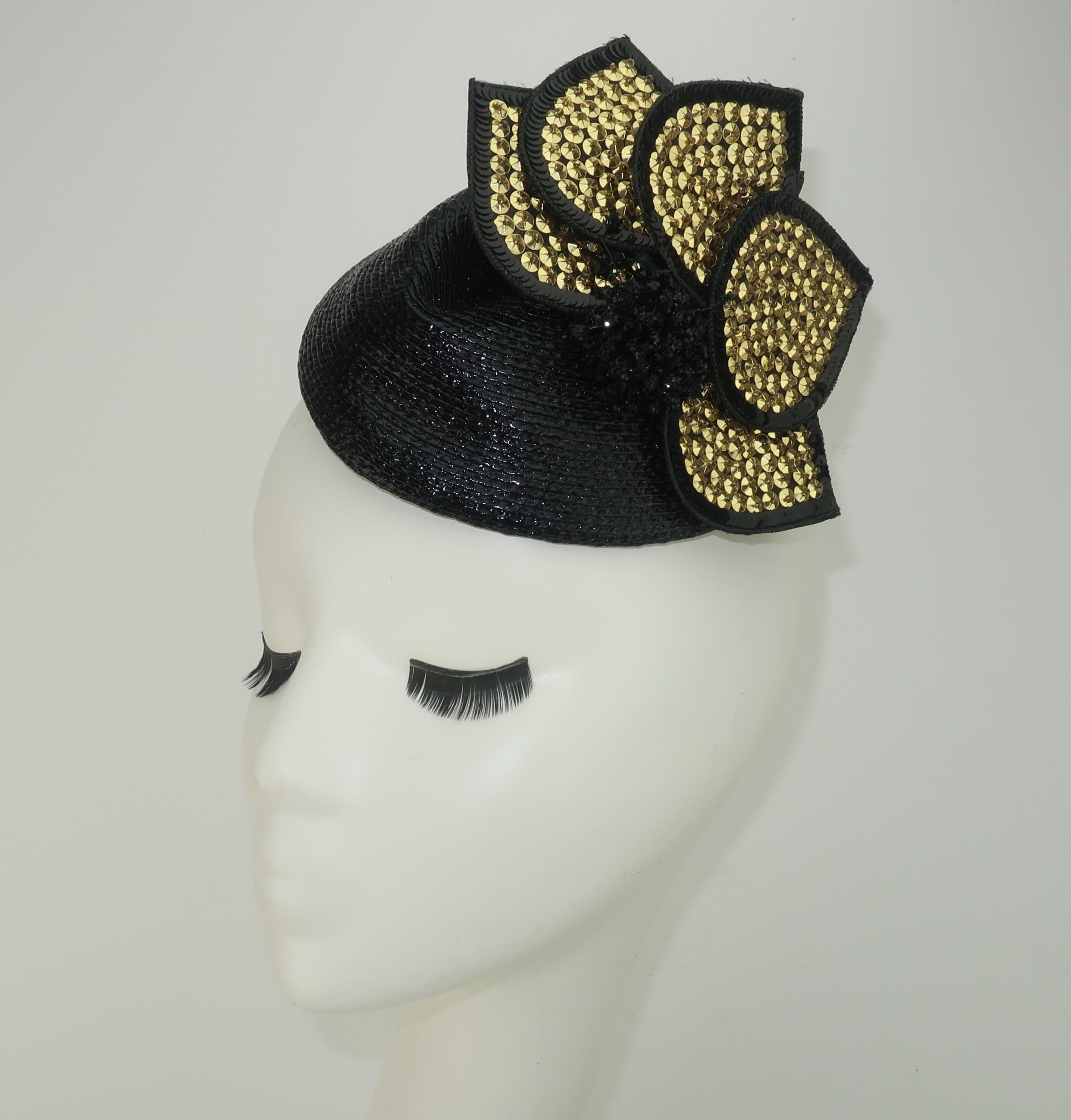 A black straw fascinator style hat with a removable gold sequin embellishment by Rosemary Peck.  Two combs are attached on the inner rim for anchoring the topper in place.  The removable embellishment could also be worn as a brooch.  From the living