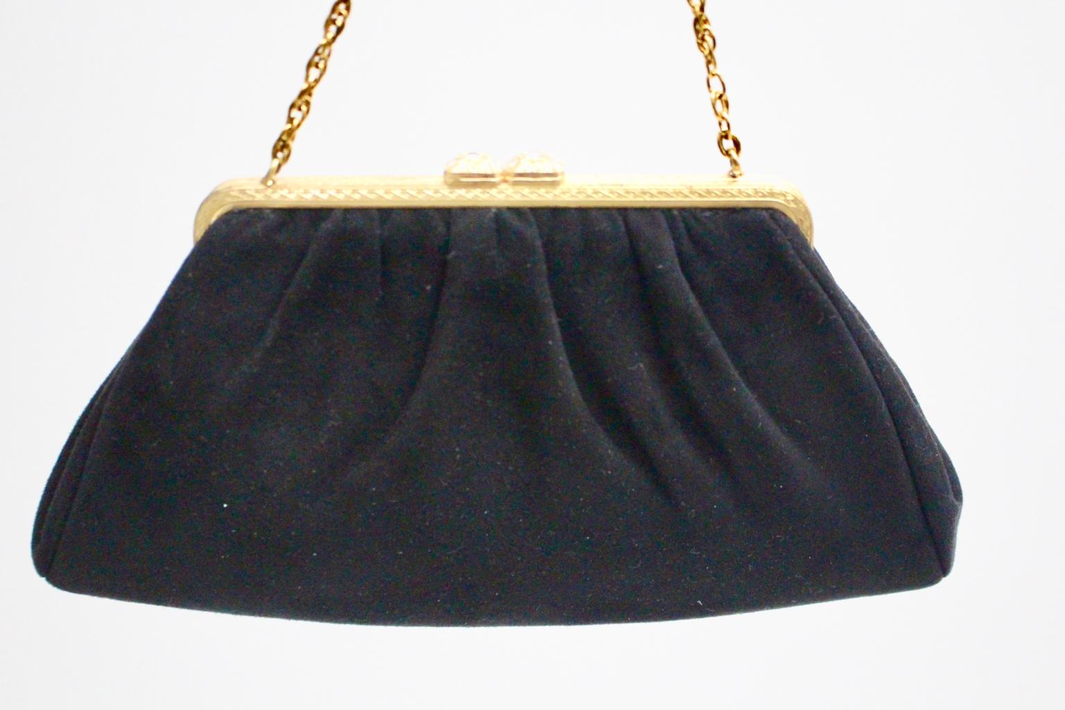 This evening bag was made of black suede leather and lined with off white moire.
The chain handles and the bag frame were made of golden metal with minor signs of age and use.
Furthermore the closure is embellished with glass stones. 
This evening