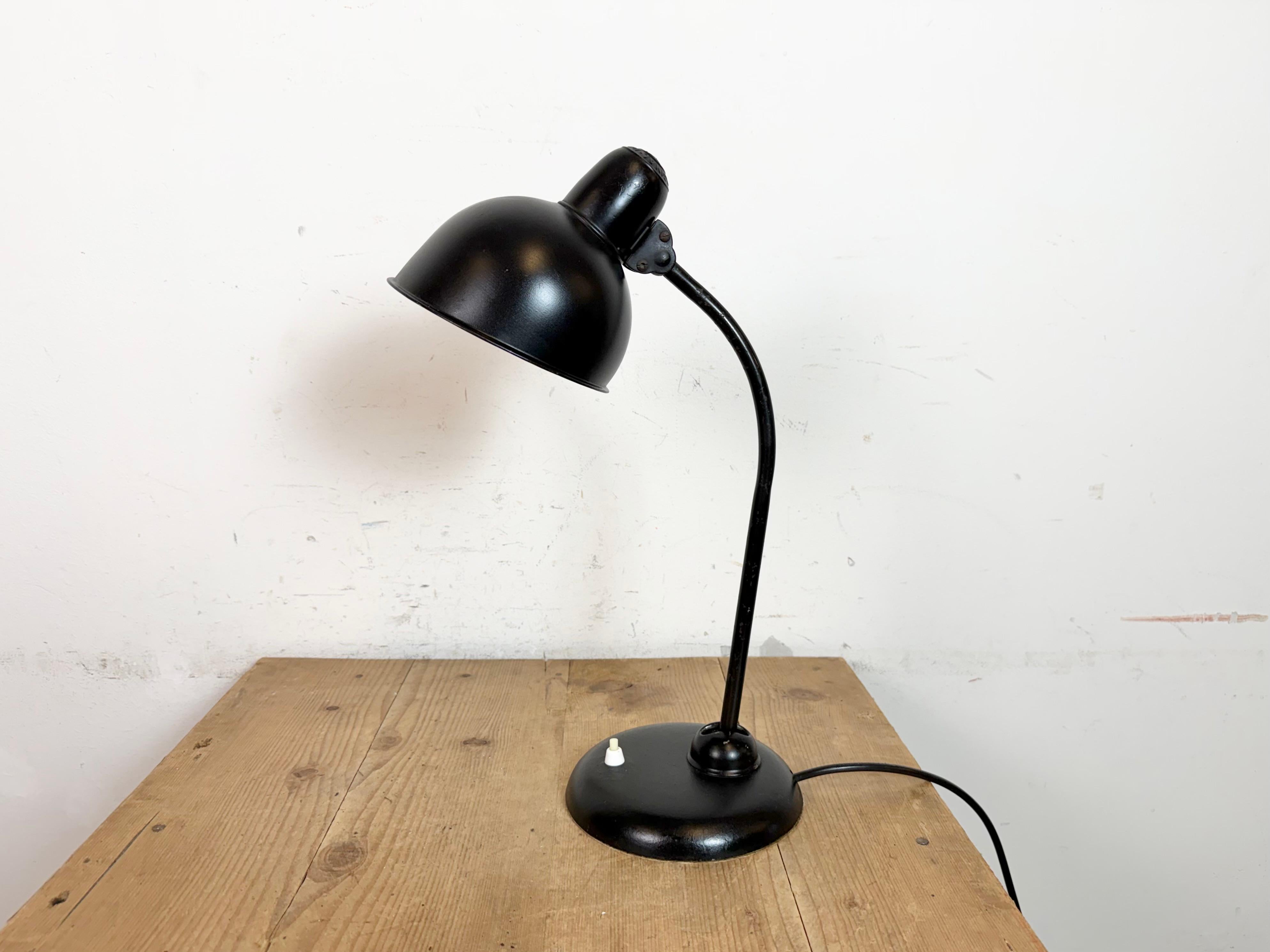 Vintage black industrial Bauhaus table lamp designed by Christian Dell and produced by Kaiser Idell in Germany during the 1930s. It features a metal shade,an iron arm with two adjustable joints and cast iron base. The socket requires standard E27 /