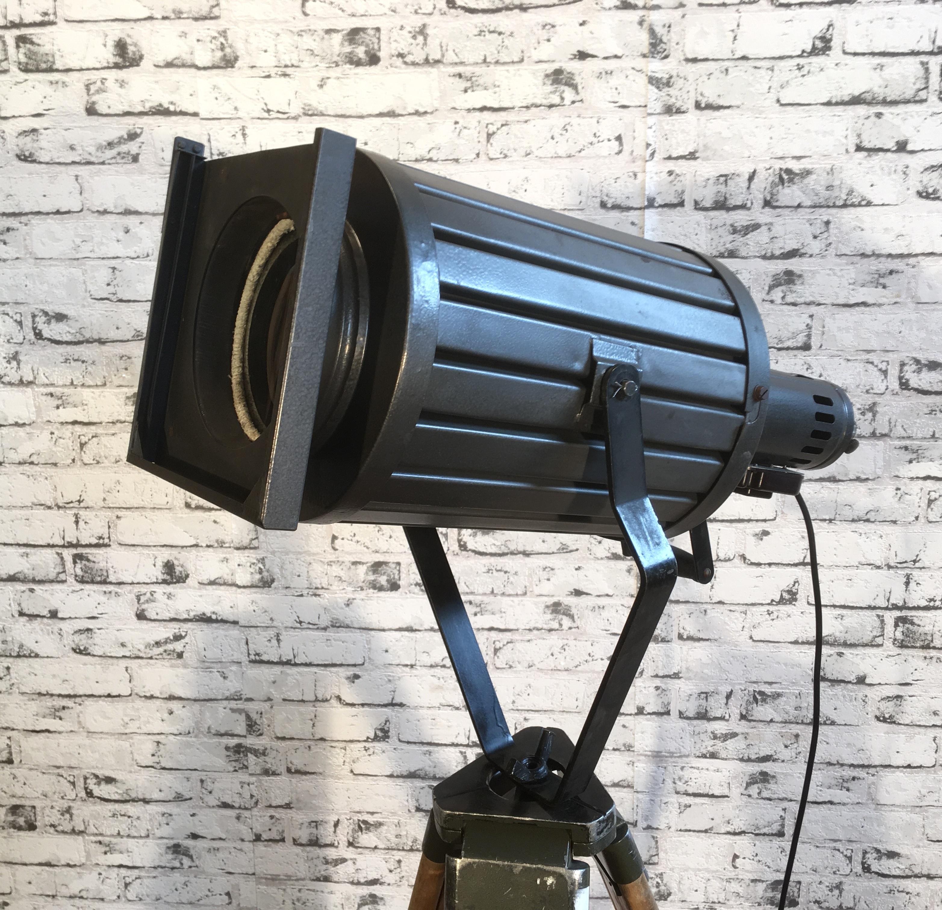 - Vintage theatre spotlight on wooden tripod made during the 1960s
- Adjustable height and angle
- Black metal body
- Clear magnifying glass
- Dimensions of the lamp: 21 x 21 cm, height: 50 cm, depth: 71 cm
- Minimum total height: 145 cm
-