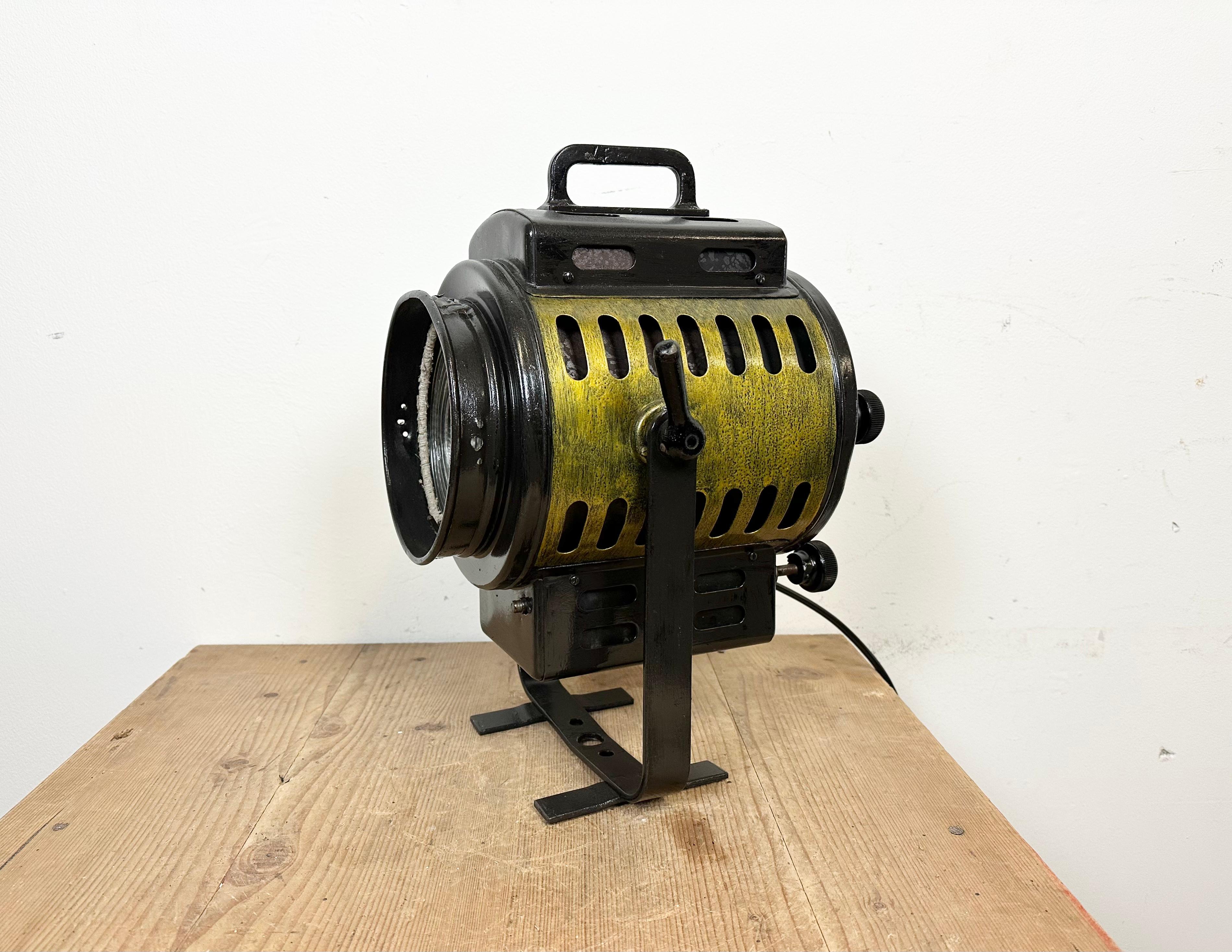Vintage theatre spotlight table lamp made in Germany during the 1960s 
It features a black metal body and a glass lens cover
The porcelain socket requires E27/ E26 lightbulbs 
New wire
The weight of the spotlight is 4.6 kg 
The diameter of the lens
